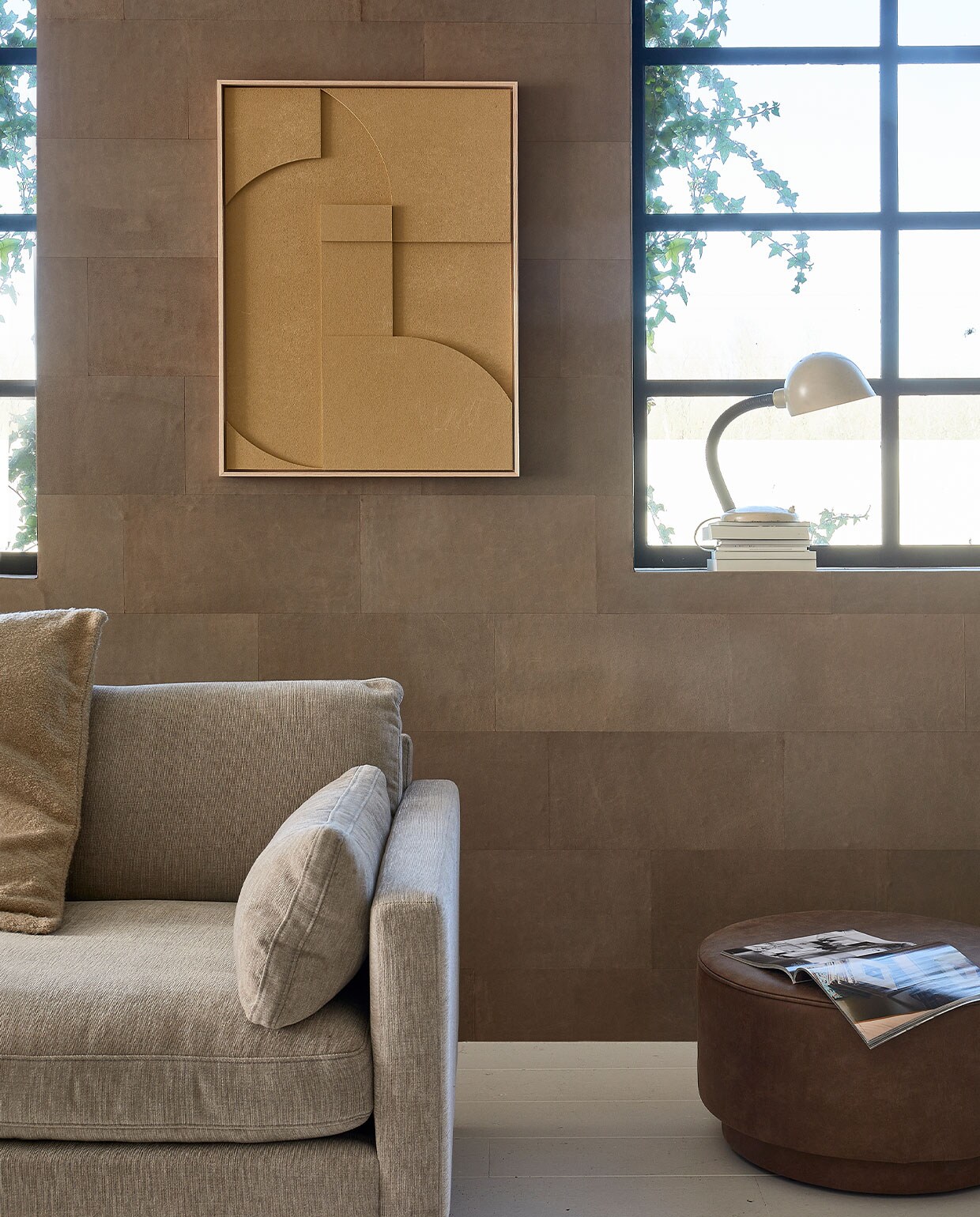 Leren wandtegels in kleur Desert, per m2 € 69,95 (enzopellini.com). Bank Summer in kleur Latte, 4,5 zits, 335 cm (b) € 2530,-, aluminium salontafel Floss, 60 cm (Ø) € 275,- (zuiver.com). Fauteuil Juno vanaf € 1549,- (eyye.nl). Handgemaakt wollen vloerkleed Hjorstvang, 160×230 cm € 349,- (ikea.nl). Leren loungemat, 150x100x6,5 cm (lxbxh) € 379,- (nahka.nl). Ecoleren poef van vtwonen in kleur Cognac, 60×36 cm (Øxh) € 159,-, plaid op bank Sahara van Malagoon, 150×125 cm € 59,95, papieren hanglamp Leena, 50×52 cm (Øxh) € 144,95, kussen, 50×70 cm € 41,90, vaasjes op vensterbank vanaf € 33,50 (vtwonen.nl). Keramische voet schemerlamp € 195,- (neeflouis.nl). Kruk € 30,- (vandijkenko.nl). Aan de wand reliëfkunstpaneel in kleur Sand, 63×83 cm € 469,-, zijden lampenkap, 36×58 cm (Øxh) € 159,- (hkliving.nl). Overig privébezit. JA | vtwonen 05-2022 | Styling Fietje Bruijn | Fotografie Dennis Brandsma