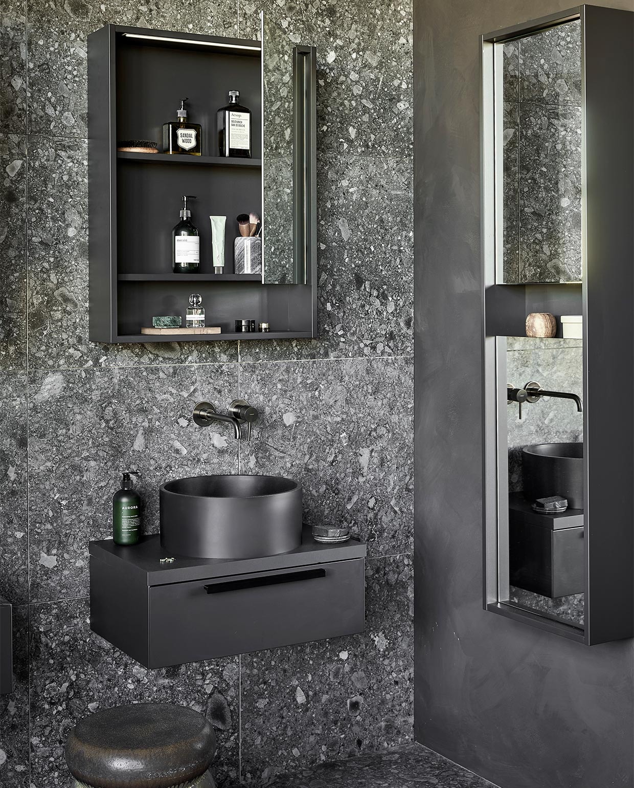 Kunststof spiegelkasten Handy Beauty in zwart, inclusief ledstrip met bewegingssensor, 60x10x80 cm (bxdxh) per stuk € 774,- (ook in breedtematen 90 cm en 120 cm en in wit, zand en grijs). Top solid waskommen Circle in zwart, 37×15 cm (Øxh) per stuk € 488,- (ook in grijs en in Marmer). Kunststof afdekblad in matzwart, 60 cm, per stuk € 145,-. Mat gelakte onderkasten Tidy in matzwart, 1 lade met handgreep, 60x40x20 cm (bxdxh) per stuk € 623,-. Spiegelkolomkast Handy Beauty Long in matzwart met 2 dubbelzijdige spiegeldeuren, 40x16x150 cm (bxdxh) € 762,- (ook in wit, zand en grijs). Top solid bad Endless in zwart, 160x73x57 cm (lxbxh), inhoud 200 liter € 4780,- (ook in grijs en in zand). Op de wand en vloer vtwonen tegels Composite Black Antracite, 60×60 cm, per m² € 65,-. M.m.v. vestingh(kleur op de muur Night Sky No.101), zarahome.com (handdoek, geurkaars in glas), vtwonen.be (rond juten vloerkleed Eternal van Ferm Living, wandlampen Cast Sconce van Menu, zwart kledingrek Dora van Ferm Living, kruk Bulb van vtwonen), nordal.eu (groen marmeren schaaltje), stories.com (tube crème, oorbellen), wonenmetlef.nl (bruine onderzetter Merge van Ferm Living). Overig privébezit. JA | vtwonen 05-2022 | styling Kim van Rossenberg  | fotografie Peggy Janssen | productie Tanja Saarberg