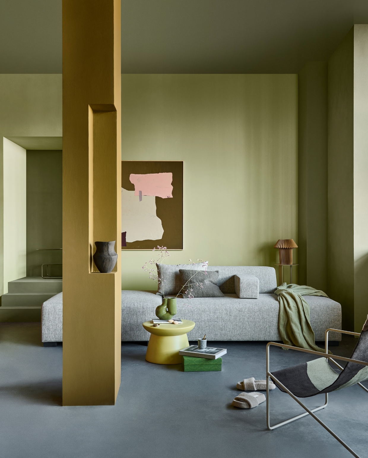 Muurverf kolom Forest, achterwand Fennel, trap, plafond, gang en rechterwand Khaki van vtwonen, liter € 23,99, 2,5 liter € 35,49. M.m.v. boxworx.nl (elementenbank), shop.vtwonen.nl (groene vaas van Hay, fauteuil, beige pilaar en donkergroene bijzettafel van Ferm Living, groene salontafel van HKliving), hm.com (papieren tafellamp, koffiemok, plaid), zarahome.com (bruine vaas, sloffen, bruin bouclé kussen), hkliving.com (schilderij). Overig privébezit. vtwonen 1-2023 | Productie Tanja Saarberg | Styling Sanne Ketelaar | Fotografie Sjoerd Eickmans