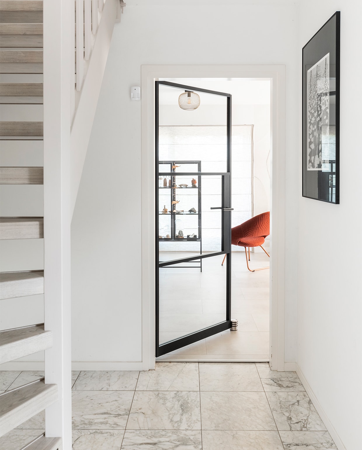 Zwartstalen stompe deur Blaak, prijs op aanvraag (gewoongers.nl). Trap geschilderd in Flexa Creations verf Urban Taupe (flexa.nl). Trap decor Shady Grey, prijs op aanvraag (upstairs.com). Vloer en foto aan de muur privébezit. vtwonen weer verliefd op je huis | seizoen 15, aflevering 5 |  styling Frans Uyterlinde | fotografie Margriet Hoekstra