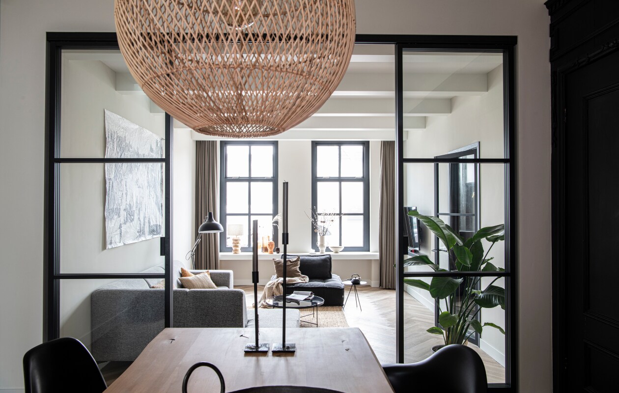 Schuifdeuren Gewoon Gers. Kunstwerken HKliving (gezicht) en Paper Collective. Tafel Karwei. Eames-stoelen Vitra. Hanglamp Maze Drop van Raw Materials. Overig onbekend. vtwonen 12-2022 | productie InsideHomePage | styling Studio Marit Saladini | fotografie Louis Lemaire