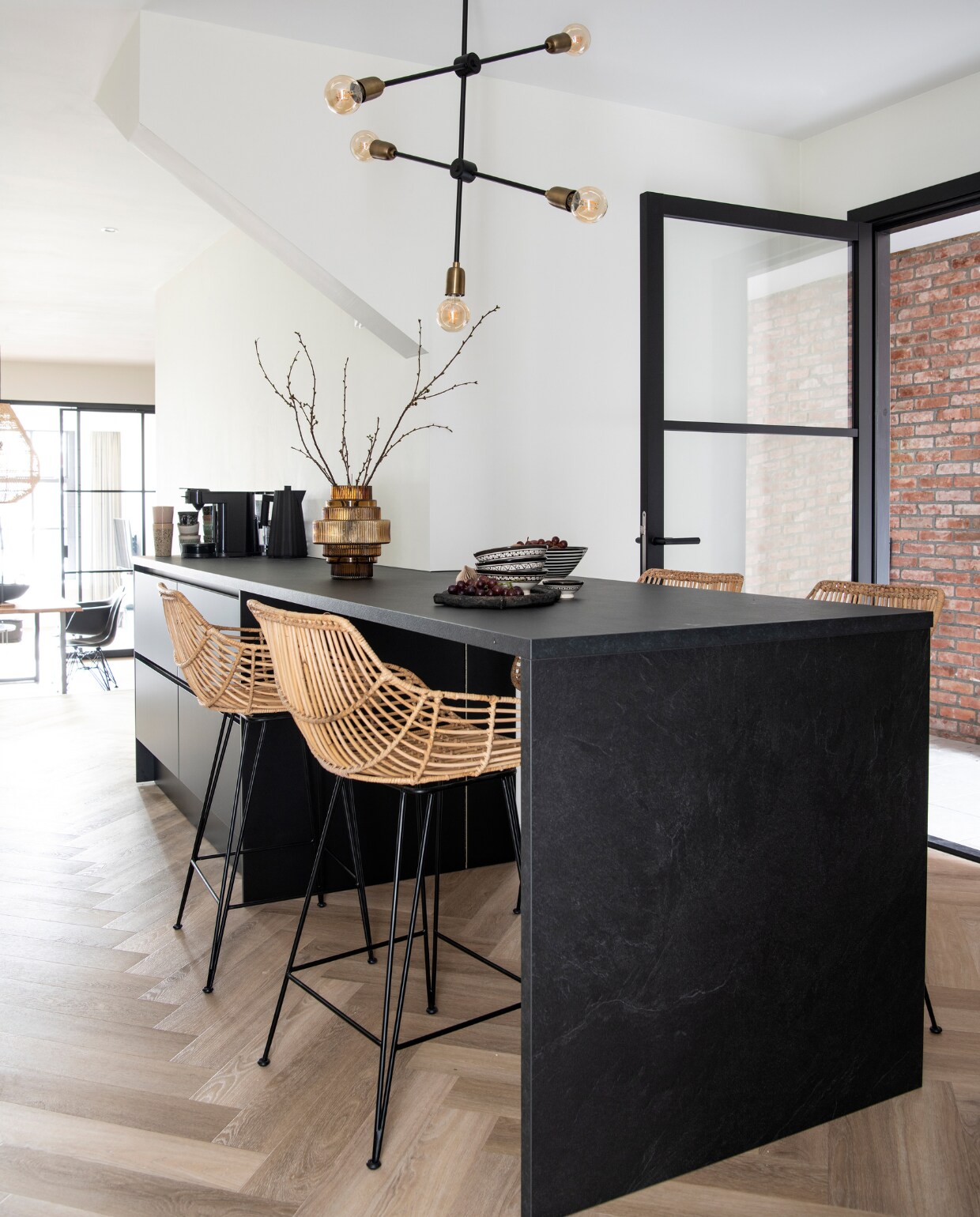 Muurverf RAL 9010. Vloer naturel eiken visgraat pvc. Keuken Keuken Kampioen. Barstoelen MeubelAsia. Mokken HKliving, zwarte waterkoker Alessi, vaas tuincentrum, kommen en bord uit Marokko. Lamp House Doctor. Overig onbekend. vtwonen 12-2022 | Productie InsideHomePage | Styling Studio Marit Saladini | Fotografie Louis Lemaire | Tekst Saskia Borst