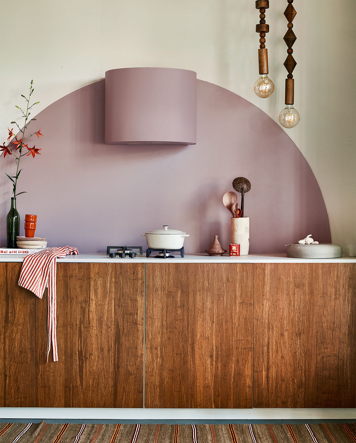 Muurverf Flexa Easycare Keuken kleur Cosmic Glory, ronde vorm en bekleding afzuigkap kleur Heart Wood, per liter ? 25,49 (flexa.nl). Bamboe fronten Destiny Caramel, 6080 cm (bxh) ? 259,-, aanrechtblad prijs op aanvraag (frontz.nl). Vloerkleed vintage, 21586 cm ? 350,- (rozenkelim.nl). Groene fles ? 7,50 (kringloop). Kookboek Home Made Basics van Yvette van Boven ? 34,99 (bol.com). Kralenlampen, per stuk ? 659,-, rode mokken ? 9,95, houten borden ? 21,-, pollepels vanaf ? 9,95, houten vijzel ? 36,-, kleine tajine ? 8,50 (householdhardware.nl). Schort ? 9,99 (hm.com). Aardewerken pan ? 39,99 (zarahome.com). Handgemaakte turnaround dish ?185,- (lilokeramiek.nl). vtwonen 09-2022 | styling Leonie Mooren | fotografie Peggy Janssen