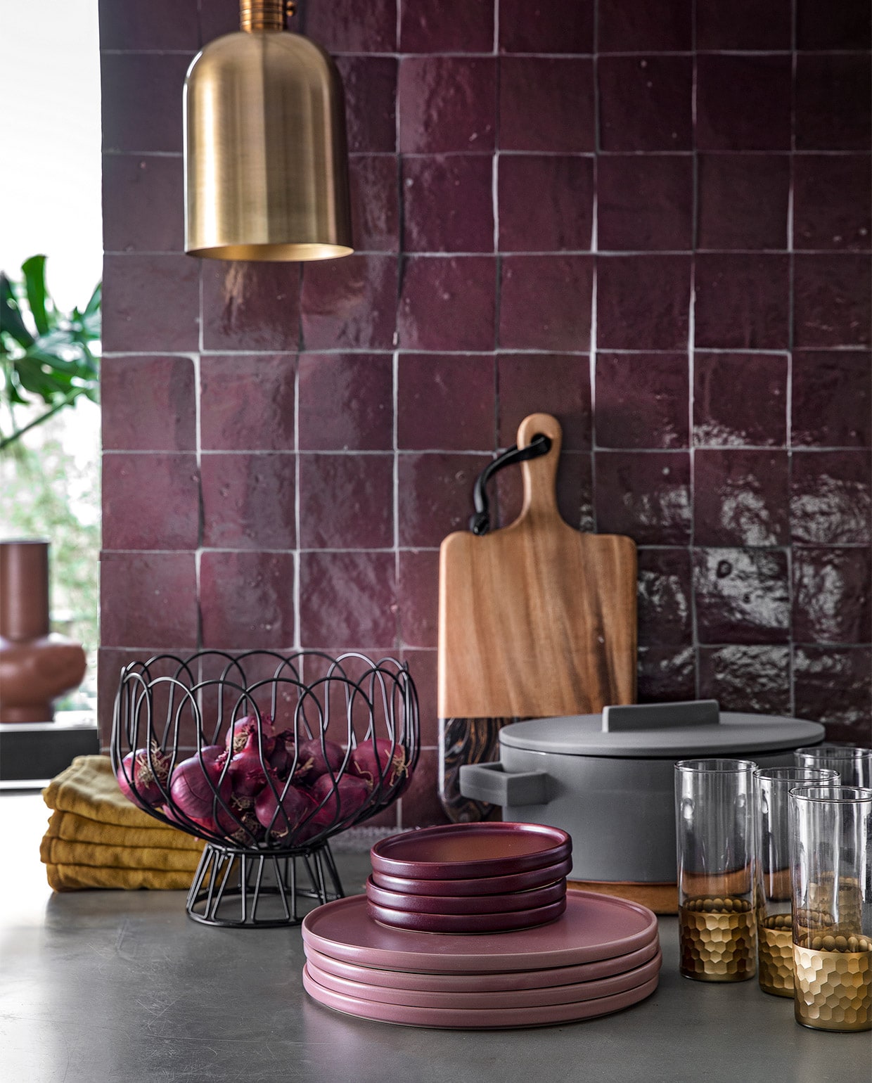 Auberginekleurige zelliges, 10×10 cm per m² € 94,50 (designtegels.nl). Bronskleurig hanglampje Aisha van Lifestyle € 69,95, draadschaal van Present Time € 17,49, grijze ovalen kookpan Terra Cotto van Eva Solo € 77,50, terraroze vaas Theseus van Urban Nature Culture € 59,95 (vtwonen.be). Plank € 47,95, ovale plank (onder de pan) € 47,95, longdrink glazen Reflexions per stuk € 10,95 (zenzahome.com). Okergele theedoeken per stuk € 3,- (hema.nl). Oudroze dinerborden per stuk € 9,99, aubergine kleurige bordjes per stuk € 4,99 (hm.com). JA | vtwonen 02-2019 | styling Moniek Visser  | fotografie Peggy Janssen