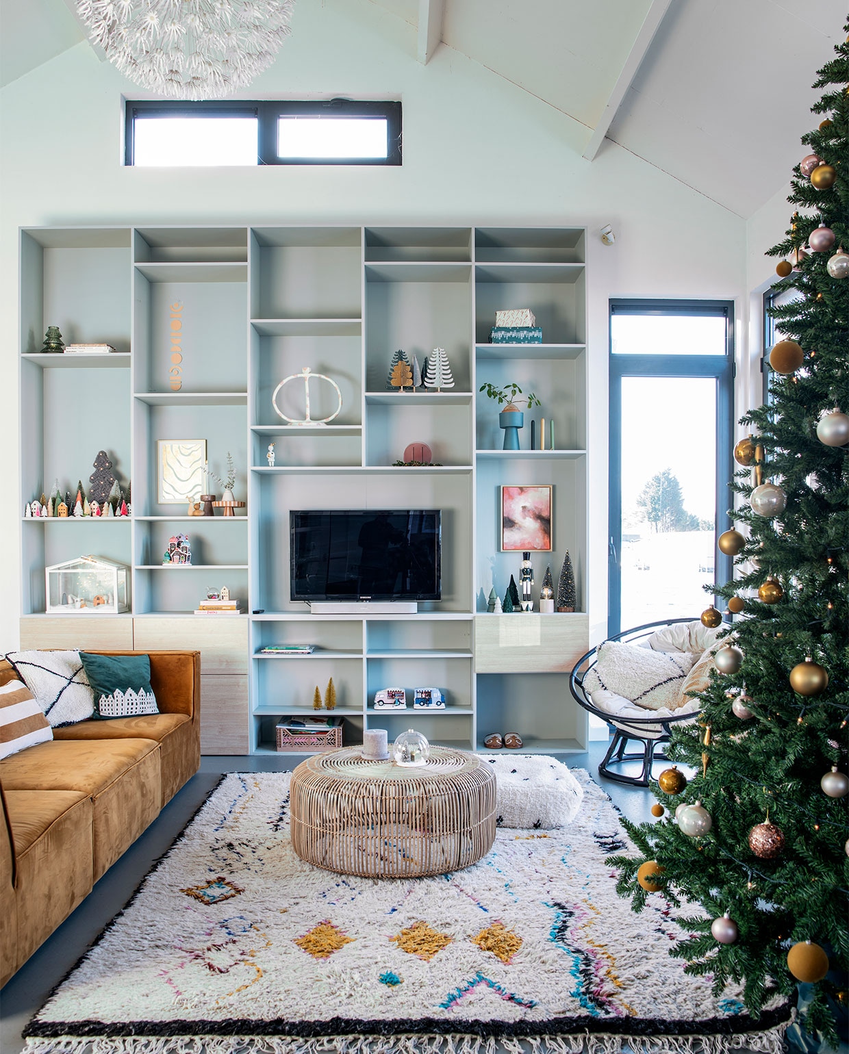 Wandkast op maat gemaakt. Winterhuisje Lemax. Kerststal in kas en hanglamp van Ikea. Papieren huisjes Jurianne Matter. Boompjes Ferm Living. Ronde/ovale witte kandelaar Junoon. Schilderij met wolken van Wendy Lammerschaag. Houten notenkraker Jysk. Mini-kerstbomen Hema en Jysk. Groene vaas, gestreept kussen Oyoy Living Design. Bank Sofacompany. Kleed, poef en wit kussen Living Maroc. Salontafel HKliving. Stoel Casa. Groen kussen V. at the City. Overig herkomst onbekend. vtwonen 12-2021 | productie Insidehomepage | styling Laura Gommans | fotografie Louis Lemaire tekst Inge van Lieshout | tekstbewerking Erik Jager