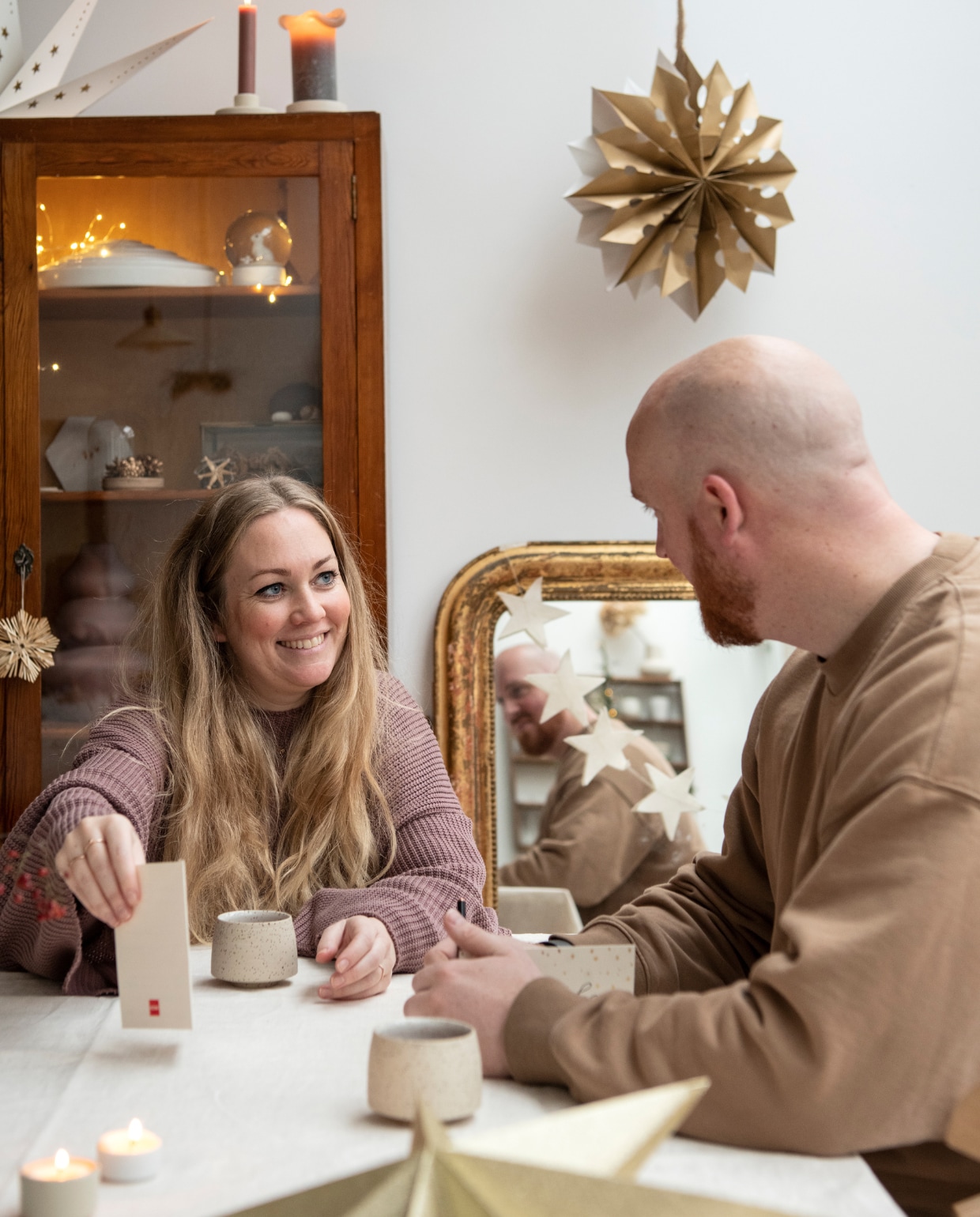 Laurien en Barry drinken een kop koffie aan de eetkamer tafel in hun jaren 30-huis. Kop Studio Timmerman, grote waxinelichthouders H&amp;M Home, porseleinen waxinelichthouders Waschbär. vtwonen 13-2022 | productie Insidehomepage | styling Myla Griese | fotografie Louis Lemaire