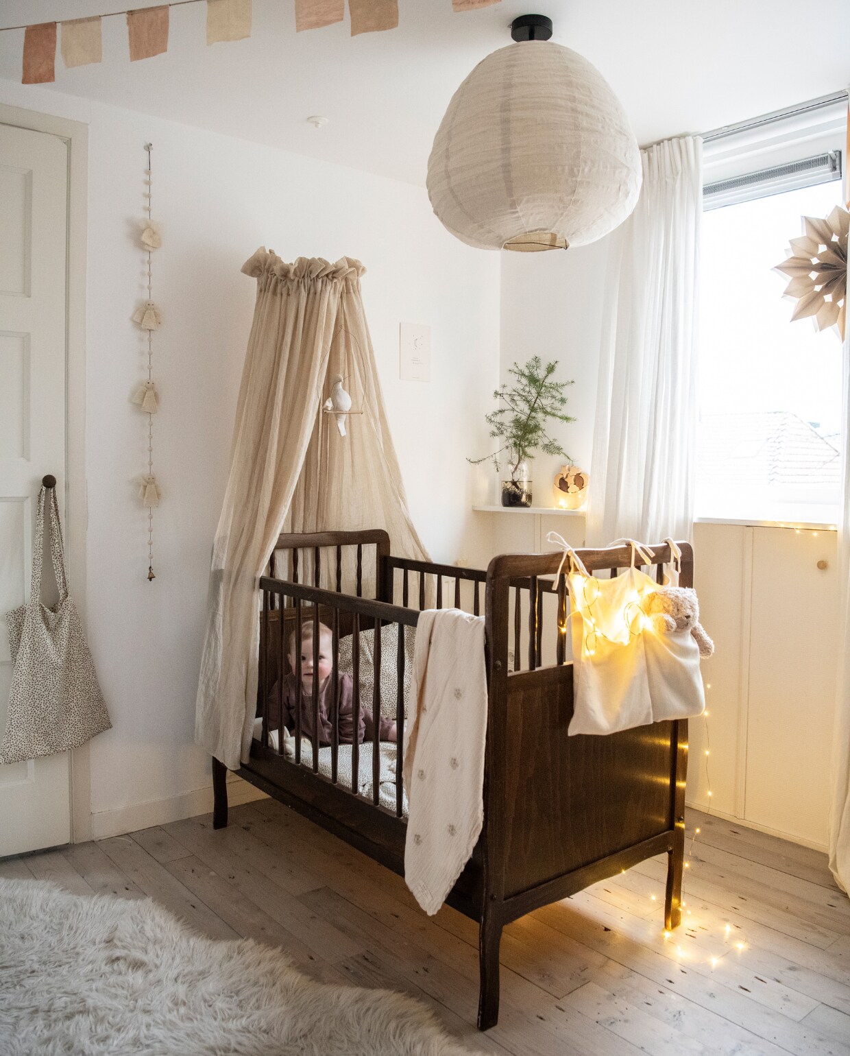 Bed kringloop, bedhemel Jollein. Katoenen zak The Archive Store. Beer Moonie van Hola BB, linnen lampion Karwei, tas Konges Sløjd. Stoffen slinger Powders &amp; Hazel, linnen gordijnen Ikea, papieren kerstster Alles in wonderland. Overig onbekend. NEE | vtwonen 13-2022 | productie Insidehomepage | styling Myla Griese | fotografie Louis Lemaire | tekst Inge van Lieshout