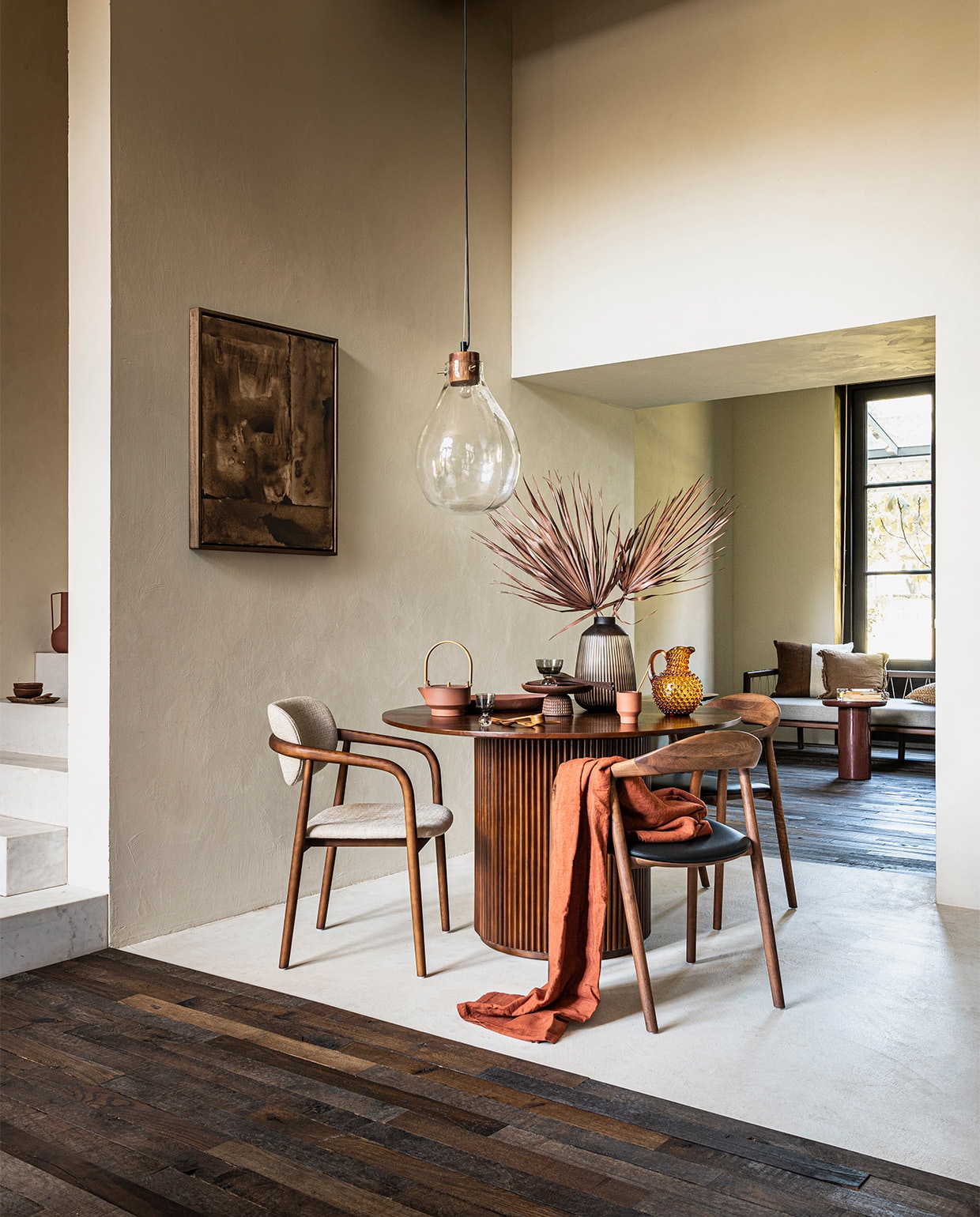 Vloer van oude eikenhouten planken, per m² vanaf € 95,- (soekijad.nl). Op trap: steenrode vaas € 35,- (mimieettoi.com). Bruine schaaltjes, per stuk € 7,99, houten lepel € 6,99 (sissy-boy.com). Kunst aan de wand, 50×60 cm vanaf € 495,- (mooswillemsen.com). Ronde eettafel € 990,- (mimiettoi.com). Eetkamerstoel Henry met ecru zitting € 399,-, steenrode bijzettafel, 40×50 cm (Øxh) € 399,- (polspotten.nl). Eetkamerstoelen met leren zitting van Muuto, per stuk € 889,- (vantil.nl). Glazen hanglamp € 99,- (hm.com). Terracotta theepot € 130,-, terracotta beker € 19,-, kussen met bruine en ecru vlakken € 96,- (letoile.store). Glazen op bolvoet, per stuk € 16,-, bruine glazen karaf € 100,-, terra tafelkleed € 85,- (paviljoennoord.com). Steenrode schaal € 14,- (sissy-boy.com). Houten etagère € 163,- (homestede.nl). Vaas € 39,99 (nijhofbaarn.nl). Houten lepels, per stuk vanaf € 6,99, bruin linnen kussen € 22,99 (zarahome.com). Walnoothouten daybed Hadley € 849,- (sofacompany.com). Overig privébezit. vtwonen 11-2021 | styling Danielle Verheul | fotografie Sjoerd Eickmans