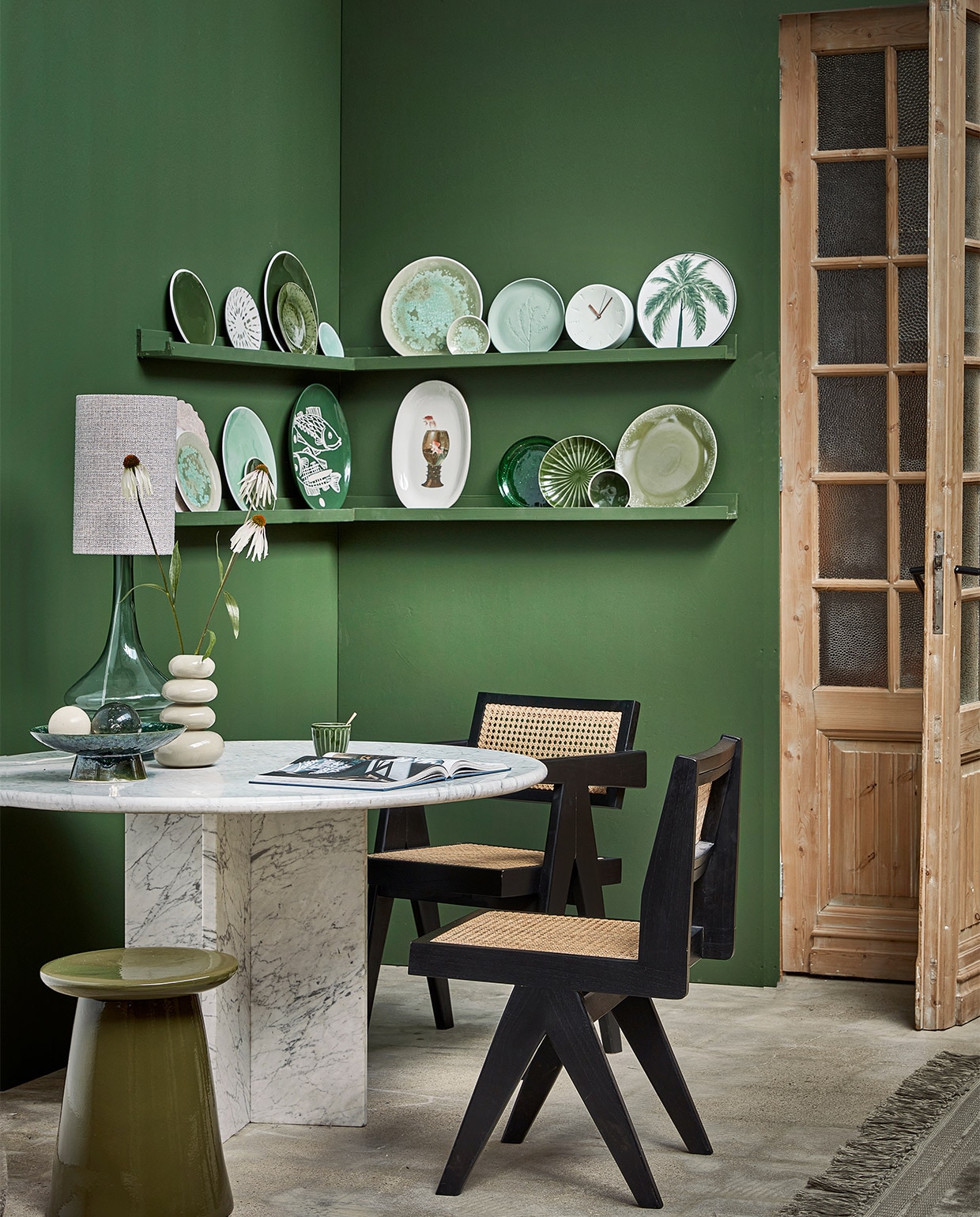 Op de muur extra matte verf Flexa Pure Colorlab 2018 Full Jade, 1 liter € 33,99 (flexa-pure.nl). Houten deuren prijs op aanvraag (empire-bv.nl). Eettafel van Carrara-marmer € 2150,-, Pierre Jeanneret-stijl eetkamerstoel vanaf € 475,- (cocooncollectables.nl). Lampenvoet Straw, 22 cm (Ø) € 119,-, lampenkap Chunky, 20×32 cm (Øxh) € 49,95, keramieken kruk Button van vtwonen, 35×45 cm (Øxh) € 129,- (basiclabel.nl). Fruitschaal The Emeralds € 79,95, mok The Emeralds, set van 4 € 24,95 (hkliving.nl). Vaas Pebbles € 49,99 (urbannatureculture.com). Vloerkleed Ravel, 170×240 cm € 329,- (bepurehome.com). Fotoplank Avnede, 115×7 cm € 10,- (jysk.nl). Borden bovenste rij: groene borden met witte rand Green 091 klein € 35,- en groot € 49,-, klein turquoise bord Green 233 € 14,-, turquoise bord met verweerd glazuur Green 021 groot € 35,- en klein € 14,-, bord met plantenreliëf Green 05 € 30,-, porseleinen klok € 85,- (harmenelke.nl). Wit gebaksbord met groene vlekken Arts &amp; Craft Sparks € 12,95 (urbannatureculture.com). Groen geglazuurd bord The Emeralds, set van 2 € 24,95, bord met palmboom € 11,95 (hkliving.nl). Onderste rij: turquoise bord met verweerd glazuur Green 021 € 35,-, groot turquoise bord Green 233 € 49,-, groen bord Green 091 € 14,- groen bord Green 062 € 14,- (harmenelke.nl). Wit brocante bord € 84,- (ingridwens.nl). Bord met vis Arts &amp; Craft Fishes € 49,95 (urbannatureculture.com). Witte serveerschaal met bokaal € 85,- (lylies.nl). Groen geglazuurd bord The Emeralds, € 6,95, groen bord met reliëf The Emeralds, set van 2 € 22,95, dinerbord 70’s, set van 2 € 27,95 (hkliving.nl). JA | vtwonen 10-2022 | styling Kim Timmerman | fotografie Peggy Janssen