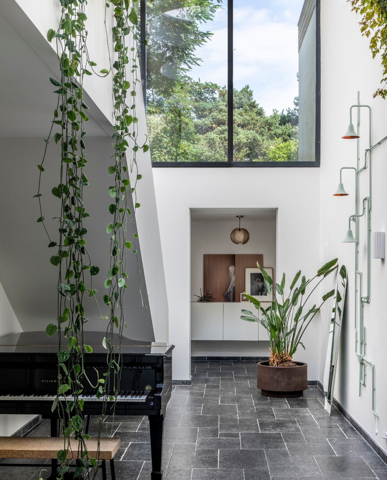 Muurverf schrobvaste RAL 9010 Flexa. Balustrade met hangplanten eigen ontwerp. Gipsen object met bloemen Studio Amber Isabel. vtwonen 07-2022 | styling Brenda van Roekel - Studio Amber Isabel en Lotje Deinum | fotografie Denise Zwijnen