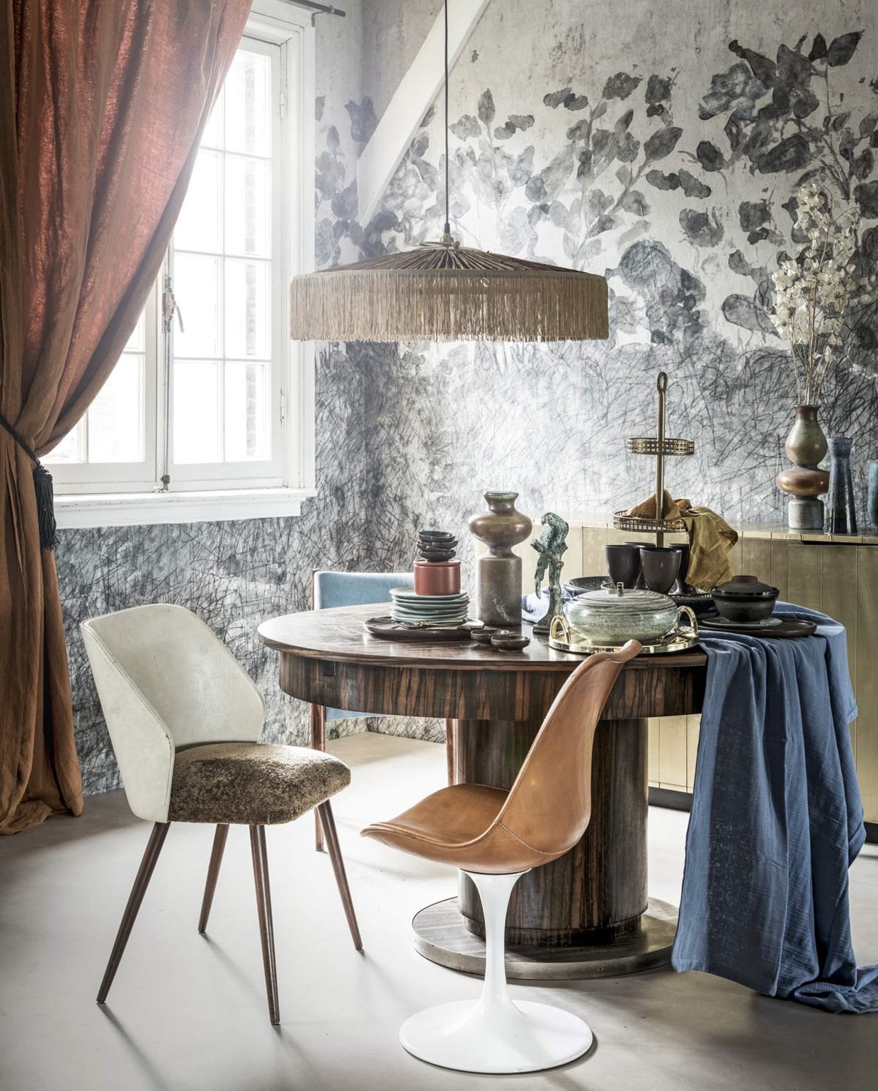 Novilon vloer kleur zand, breedte 200-400 cm, per m² € 27,99 (vtwonen.nl/vtwonen-collectie). Op maat gemaakt behang prijs op aanvraag (Wall&decò). Linnen gordijn € 279,-, leren kwast € 35,-, bruinleren stoel met witte voet € 599,- (Brecht Murré Atelier). Tafel € 723,-, blauwe stoel € 295,-, smalle vaas € 35,- (Neef Louis). Bruine stoel met witte leuning € 50,- (Van Dijk & Ko). Hanglamp € 349,- (MaisonNL). Blauw-oranje vazen met bolle vormen € 62,50 en € 72,50 (The Wunderkammer). Gouden kast € 62,50, etagère gold € 99,95 (Loods 5). Blauwe borden van HK Living, per stuk € 7,95, bruin potje met deksel van Madam Stoltz € 13,49, grote blauwe schaal van Casa Vivante € 49,95 (vtwonen.nl). Geel servet € 4,99, oranje bakje, set van 2 € 9,99 (H&M). Gouden schaal € 45,99 (Zara Home). Vogelbeeldje € 55,- (Harlequin Antiek). Tafelkleed, 140×250 cm € 140,-, bruine beker € 15,-, bruine borden € 20,-, bruine kommetjes € 8,95 (Tine K Home). Blauwe schaal met deksel € 32,95 (Things I Like Things I Love). Gouden bestek vanaf € 9,95 (Anna + Nina). vtwonen 10-2018 | fotografie Sjoerd Eickermans | styling Liza Wassenaar