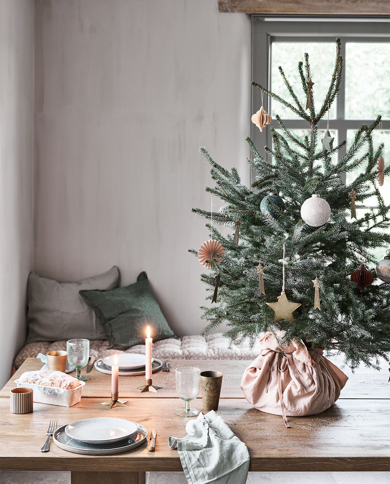 In de boom: papieren waaier € 1,49, groene bal € 2,99, bal met sneeuw € 2,49, groene ster € 1,99, honeycomb ornament € 2,79 (intratuin.nl). Messing vallende sterren € 3,50 (weldaad.com). Grote messing ster van Madam Stoltz € 7,- (deens.nl). Op tafel: servet € 2,38 (sostrenegrene.com), waxinelichthouder € 3,29 (intratuin.nl). Messing beker € 19,95, kandelaar in stervorm € 3,95 (weldaad.com). Groen wijnglas van Nordal € 11,50 (deens.nl). Zitkussen Nisha rose 50×155 cm (lxb) € 95,-, groen kussen van Bungalow 50×50 cm € 61,- (scandicliving.nl). Zachtgroene kussensloop 50×60 cm € 39,95 (yumeko.nl). vtwonen 12-2020 | styling Marlies Does | fotografie Bart Brussee
