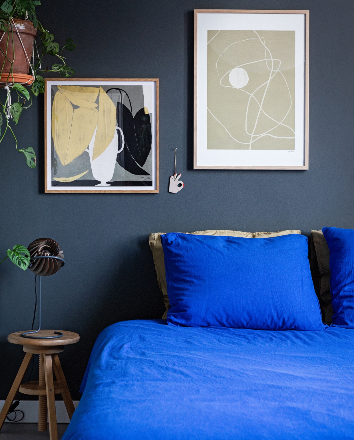 Muurkleur RAL 7043. Beddengoed Midnatt, bureaulamp Tjalle &amp; Jasper, prints, planten via Nørd Conceptstore. Keramieken handje Mette Marie Bang. Vintage Ikea kruk. vtwonen 10-2022 | styling Ilona Jongepier | fotografie Dana van Leeuwen