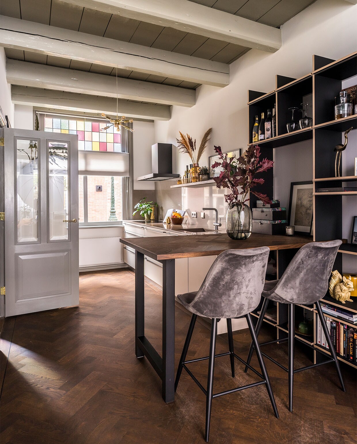 Zwart gebeitste kast van MDF met geïntegreerde bartafel eigen ontwerp, zonder schroeven en spijkers gemonteerd. Wijnglazen Broste Copenhagen. Stier geboetseerd door Jennifers vader, een van de vaasjes komt uit pottenbakkerij Dinges van Boys vader. Vaas Made, lamp Moody Zuiver, gouden reiger Skyler. NEE | vtwonen binnenkijken special 2021 | producie CoCo Features | fotografie Muk van Lil, Chiela van Meerwijk