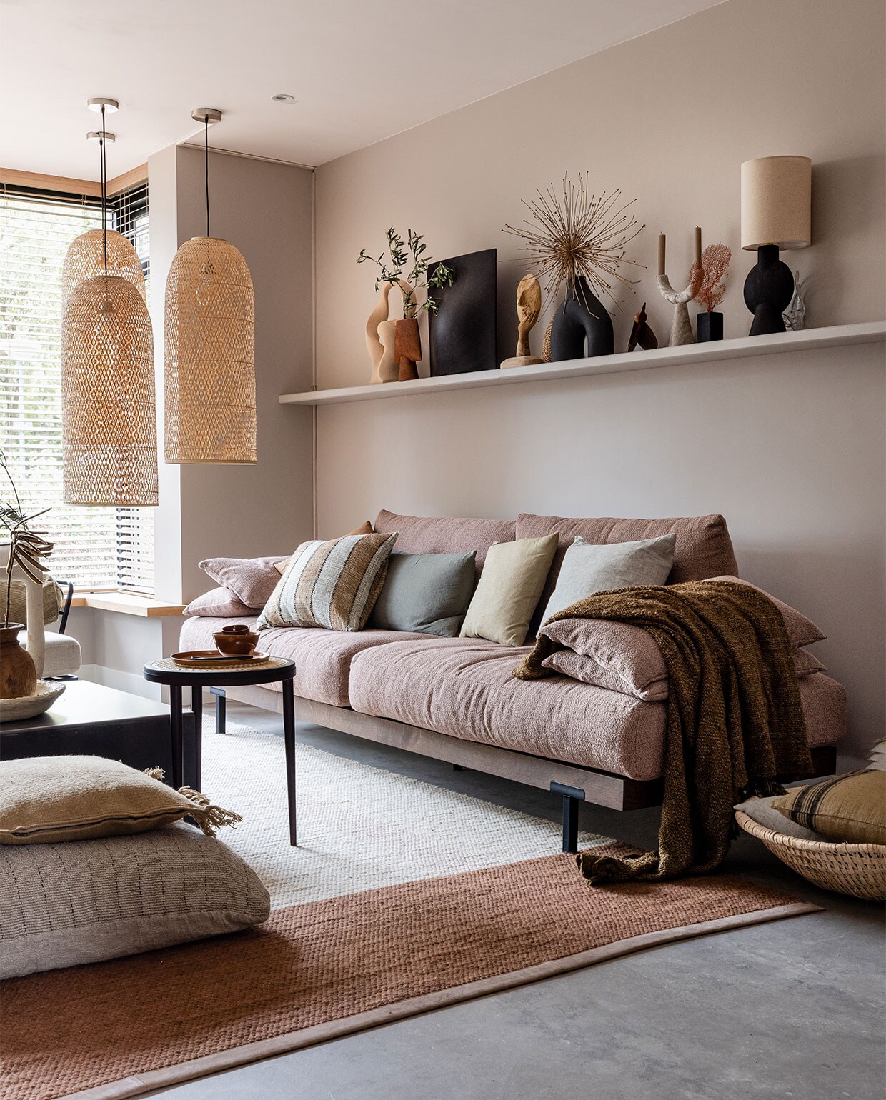 Flexa Creations muurverf Urban Taupe, plank DIY (info@bminterieurmakers.nl) in kleur Urban Taupe (flexa.nl). Raambekleding prijs op aanvraag, pvc-vloer betonlook Dynamic Cemento 609 met plint (woninginrichting-aanhuis.nl). Hanglampen Cap Natural per stuk € 570,- (ayilluminate.com). Bank Pacha van Eijerkamp Collectie € 2925,-, gevlochten mand naast bank Urban Nature Culture € 84,-, kussen Linen Dark in mand HKliving € 29,95, salontafel Industry van Feelings € 299,-, bijzettafel Hako van 101 Copenhagen € 352,-, vloerkleed Red Chain van Label € 2405,-, groot kussen op grond Mayla € 167,-, zandkleurig kussen Kelim Fringe Ferm Living € 75,- (eijerkamp.nl). Op plank boven bank van links naar rechts: sculptuur Bloomingville € 84,99 (nordicnest.nl), vaas Sphere Vase 101 Copenhagen € 59,-, vaas Origami Vase Big Coffee € 179,- (eijerkamp.nl), ornament Deco Gezicht Bloomingville € 64,90 (vtwonen.nl), handgeweven waaier € 36,- (couleurlocale.eu), zwarte vaas met twee poten € 34,99 (hm.com), houten vogel van Gazzda € 75,- (eijerkamp.nl), stenen kandelaar met twee armen € 70,- (nordal.eu), decoratievorm op zwarte voet, vanaf € 99,- (violierathome.nl), tafellamp Bloomingville € 115,- (vtwonen.nl). Effen kussens op bank vanaf € 39,- (bymolle.com). Kussen met streep House Doctor € 52,-, plaid The s’il vous Plaid Brown € 129,95 (eijerkamp.nl). Op salontafel papier-maché schaal van Lightmakers € 34,99 (eijerkamp.nl). Vaas Tamegroute Natural Vase Jerrycan € 115,- (householdhardware.nl). Houten vaas van New Routz € 54,95 (vtwonen.nl). Op bijzettafel bord € 18,70 en kom van Urban Nature Culture € 10,95 (vtwonen.nl). Lepels op bord New Edition HomeSalad Servers, set van twee € 12,95 en € 14,95 (eijerkamp.nl). Planten en droogbloemen (plantje.nl). JA | vtwonen weer verliefd op je huis | seizoen 15, aflevering 7 | styling Liza Wassenaar | fotografie Sonja Velda