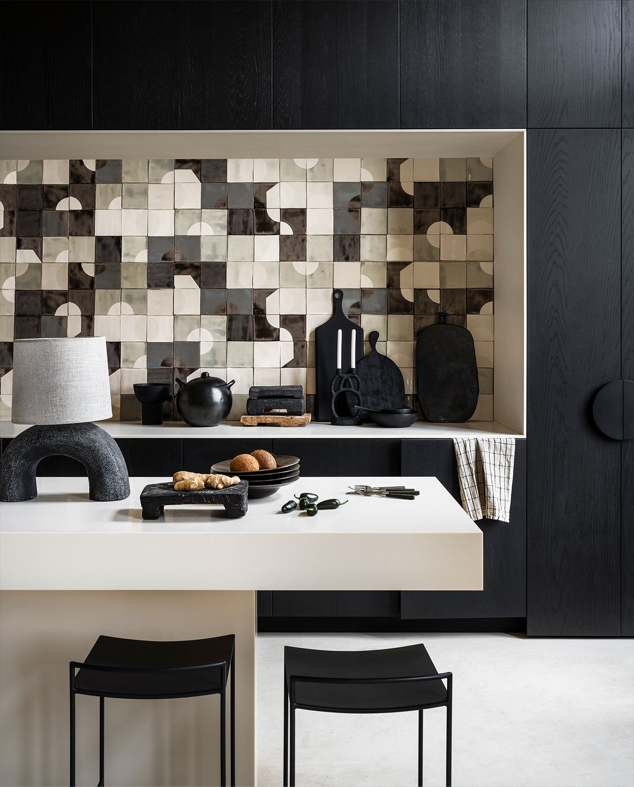 Handgemaakte tegels per m² vanaf € 3000,- (smink.studio). Ontwerp keuken via anoukb.com. Lampenvoet € 319,- lampenkap € 39,95 (lanena-home.com). Diepe borden € 24,95 (hkliving.nl). Bestek vanaf € 3,95 (dille-kamille.nl). Houten schaal op voet, 20×20 cm (Øxh) € 49,95, ronde snijplank € 41,95, houten schalen vanaf € 20,95, lepel € 10,95 (urbannatureculture.com). Grote kookpot vanaf € 61,30 (blackpottery.eu). Hoge snijplank van Bloomingville € 64,90, kandelaar van Bloomingville € 36,90, barkruk van Serax € 194,- (vtwonen.be). Theedoek € 15,- (misterdesign.nl). Zwarte vaas van Willem van Hooff, prijs op aanvraag (willemvhooff.com). vtwonen 10-2021 | styling Marianne Luning | fotografie Stan Koolen