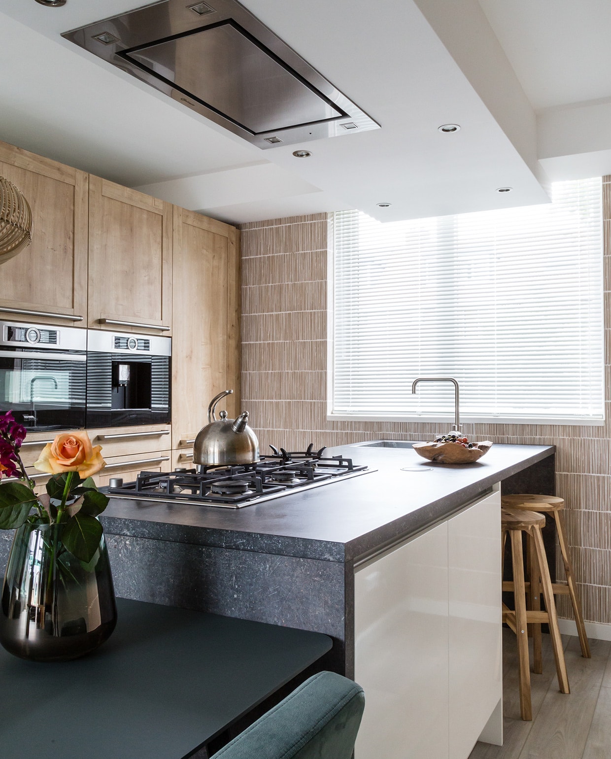 Muurverf 85% Hardsteen (flexa). Behang Terra 391513, per rol € 69,95 (eijffinger.com). Hanglampen Kalahari van Good&amp;Mojo, per stuk € 205,-, eetkamertafel New Classic van Studio Henk € 1900,-, eetkamerstoelen Ode van Studio Henk, per stuk € 279,-, posters Floating Leaves van Moebe, per stuk € 26,95 (eijerkamp). Vaas van pt € 36,95, kandelaar van Bloomingville € 33,- (vtwonen.be). Keuken, kaars, waterkoker, bloemen, houten schaal privébezit. vtwonen weer verliefd op je huis | seizoen 11, aflevering 3 | styling Fietje Bruijn | fotografie Barbara Kieboom