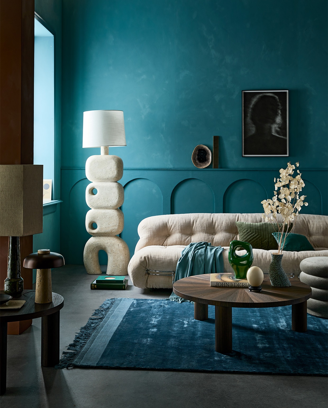 Kalkverf op de muur 87 Petrol, 2,5 liter € 126,- (lauthentique.nl). Lamp Reverse van Menu, travertijn en messing € 550,- (menuspace.com). Poef Faded Velvet van Ferm Living € 695,-, bank Soriana van Cassina, 250×101 cm (bxd) vanaf € 6063,- (edha-interieur.nl). Salontafel small van Ferm living, 41×65 cm (hxØ) € 949,-, salontafel large van Ferm Living, 33×100 cm (hxØ) € 1219,-, blauw vloerkleed van Zuiver € 440,-, groene tafellamp van HKliving € 222,95, zwarte kom van vtwonen € 6,15 (vtwonen.nl). Groen keramisch ornament € 49,95, blauw jacquard kussen Doris van HKliving, 30×40 cm € 37,95, lampenkap hexagoon medium € 75,- (hkliving.nl). Blauwe plaid, 140×190 cm € 45,99, travertijn plateau € 35,99 (zarahome.com). Grote sculpturale vloerlamp van microcement € 1150,- (lanena-home.com). Ingelijste polymer etching kunstfoto van Chantal Elisabeth Ariëns (kahmanngallery.com). Groen fluwelen kussen, 40×60 cm € 59,- (nordal.eu). Overig privébezit. JA | vtwonen 01-2022 | styling Cleo Scheulderman | fotografie Jeroen van der Spek
