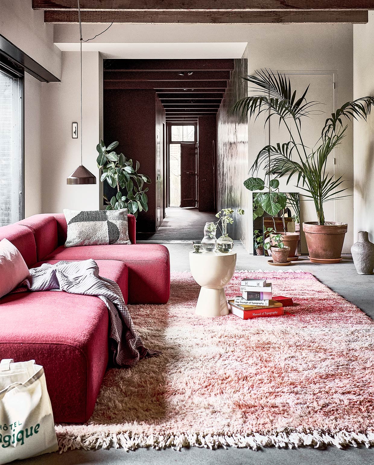 Handgemaakt wollen berber vloerkleed Beni Ouarain uit Marokko, 386×318 cm € 2790,- (rozenkelim.nl). Beige kruk van Pols Potten als bijzettafel € 325,-, sprei van Heckett &amp; Lane in kleur Quail Lilac, 180×260 cm € 36,99, kussen van Bloomingville, 40×60 cm € 69,- (vtwonen.nl). Spiegel antieklook medium € 69,95, spiegel antieklook small € 39,95 (hkliving.nl). Katoenen tas Green Magique € 35,- (hotelmagique.com). Papier-maché vaas Pompeii van BePureHome € 77,95 (basiclabel.nl). Roze elementenbank Mags vanaf € 1280,-, bruine hanglamp Lloop € 399,- (vij5.nl). Glazen karaf met ribbels € 29,- (arket.com). Overig privébezit. JA | vtwonen 04-2022 | Styling Marlies Does | Fotografie Sjoerd Eickmans
