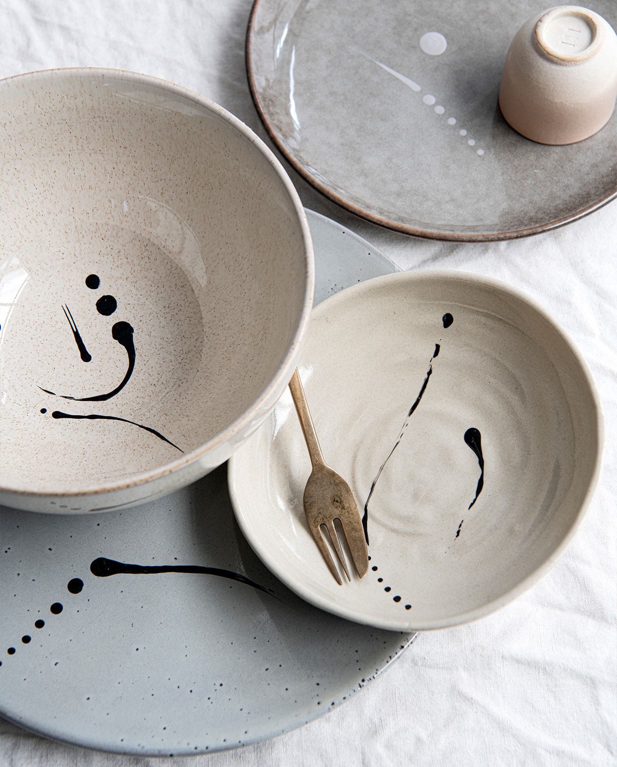 Karaf met glas van Ferm Living € 39,- (thefinestore.com). Gespikkelde mok € 19,95 (studiobloei.nl). Linnen theedoek € 12,95 (lichtenfijn.nl). Linnen tafelkleed € 49,99 (hm.com). vtwonen 07-2022 | styling Myla Griese | fotografie Louis Lemaire