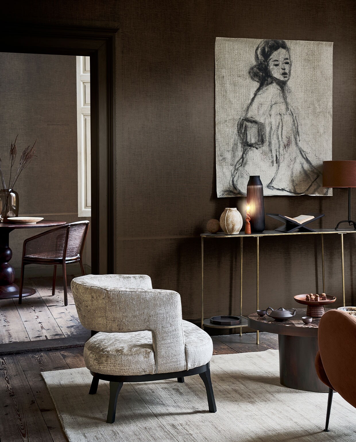 Voorste ruimte: fauteuil in champagnetint € 685,-, vloerkleed, 250×350 cm € 2999,- (allurehome.nl). Bruine fauteuil Bonnie € 429,- (made.com). Sidetable van BePureHome € 169,- (basiclabel.nl). Aardewerken vaas € 29,99, zwartmetalen tafellamp € 69,99 (zarahome.com). Gedraaide kaars € 4,95 (dille-kamille.nl). Bruine glazen vaas € 110,-, houten etagère € 140,- (homestede.nl). Houten boekenstandaard € 24,99, houten dienblad in hexagonvorm € 12,99 (hm.com). Bruine lampenkap € 45,- (lluce.nl). Salontafel met bruin marmeren blad € 1445,95 (rapture.amsterdam). Theepot € 44,95, theemokken, onderdeel van set met mokken € 59,95 (simonlevelt.nl/alkmaar). Tekening op linnen, prijs op aanvraag (gracespiegel.com). Achterste ruimte: ronde eettafel van BePureHome, 120 cm (Ø) € 629,- (basiclabel.nl). Bruine glazen vaas € 69,- (homestede.nl). Aardewerken schaal € 35,99 (zarahome.com). Eetkamerstoel € 649,- (nordal.eu). Overig privébezit. vtwonen 1-2022 | styling danielle verheul | fotografie sjoerd eickmans | locatie Landhuis Oud Amelisweerd (landhuisoudamelisweerd.nl) | assistentie sanne ketelaar, meike linthorst, willem tjalma