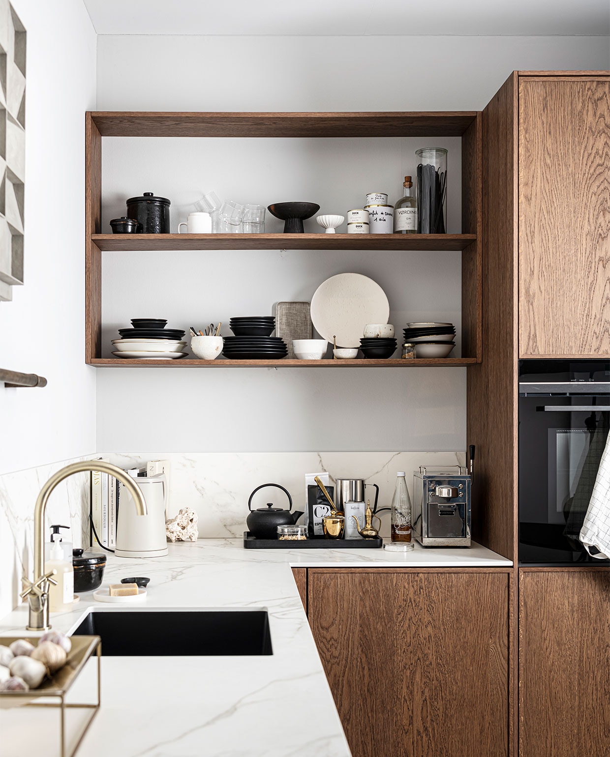 Keuken Dark Oak zoals getoond, exclusief accessoires € 19.950,- | M.m.v zarahome.com (opbergpot en bord met bordenstandaard), casagitane.com (schaal op poot), vtwonen.be (glazen en servies van vtwonen), sjostrandcoffee.nl (koffiezetapparaat en melkopschuimer), vtwonen.nl (dienblad en theepot van Serax, waterkoker Sowden van Hay), thefinestore.com (dienblad). Overig privébezit. vtwonen 12-2021 | productie Tanja Saarberg | styling Kim van Rossenberg | fotografie Sjoerd Eickmans