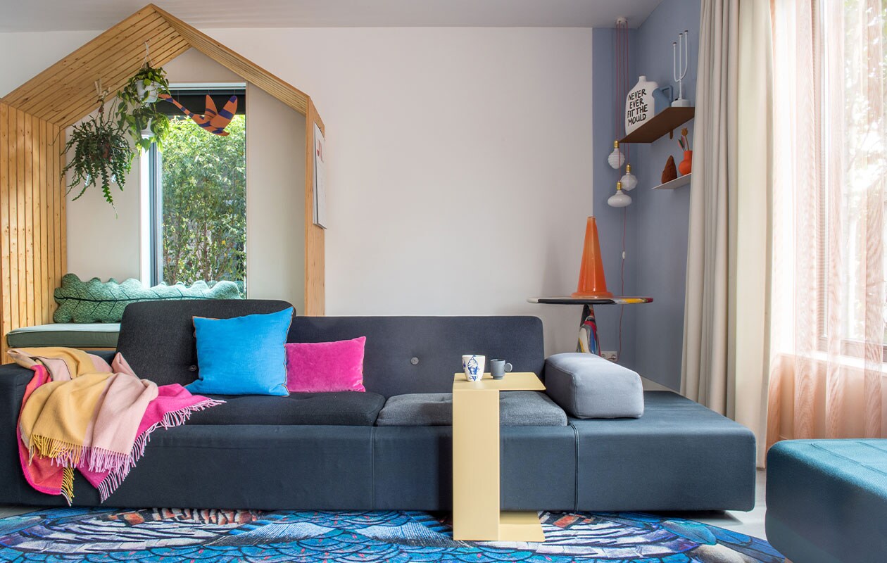 Speelhuis eigen ontwerp by Maykel, bladkussen Donna Wilson, zwaan Jantien Baas. Bank Polder Sofa en plaid Hella Jongerius voor Vitra, vloerkleed Moooi Carpets, blauw kussen Hay, paars kussen Nijhof, bijzettafel Gelderland Ori, kopje links Social Label, rechts Maarten Baas, poef Normann Copenhagen. Tafel in hoek Dirk Vander Kooij, kunstwerk Save me Glass Traffic Cone van Bas Kosters, wandplanken Muller van Severen, vaas Irenic Mould van Birgit Verwer via Cor Unum, karaf Muuto, kandelaar Chris Kabel voor Droog Design, duif Christien Meindertsma, oranje vaas Raawii, lampen Zangra. Vitrage van Kvadrat-stof, overgordijnen gemaakt door stoffeerder, kleur op muur onbekend. vtwonen 2-2022 | styling Kim de Groot | fotografie Anke Leunissen | tekst Mirjam Rosema-Verhulst