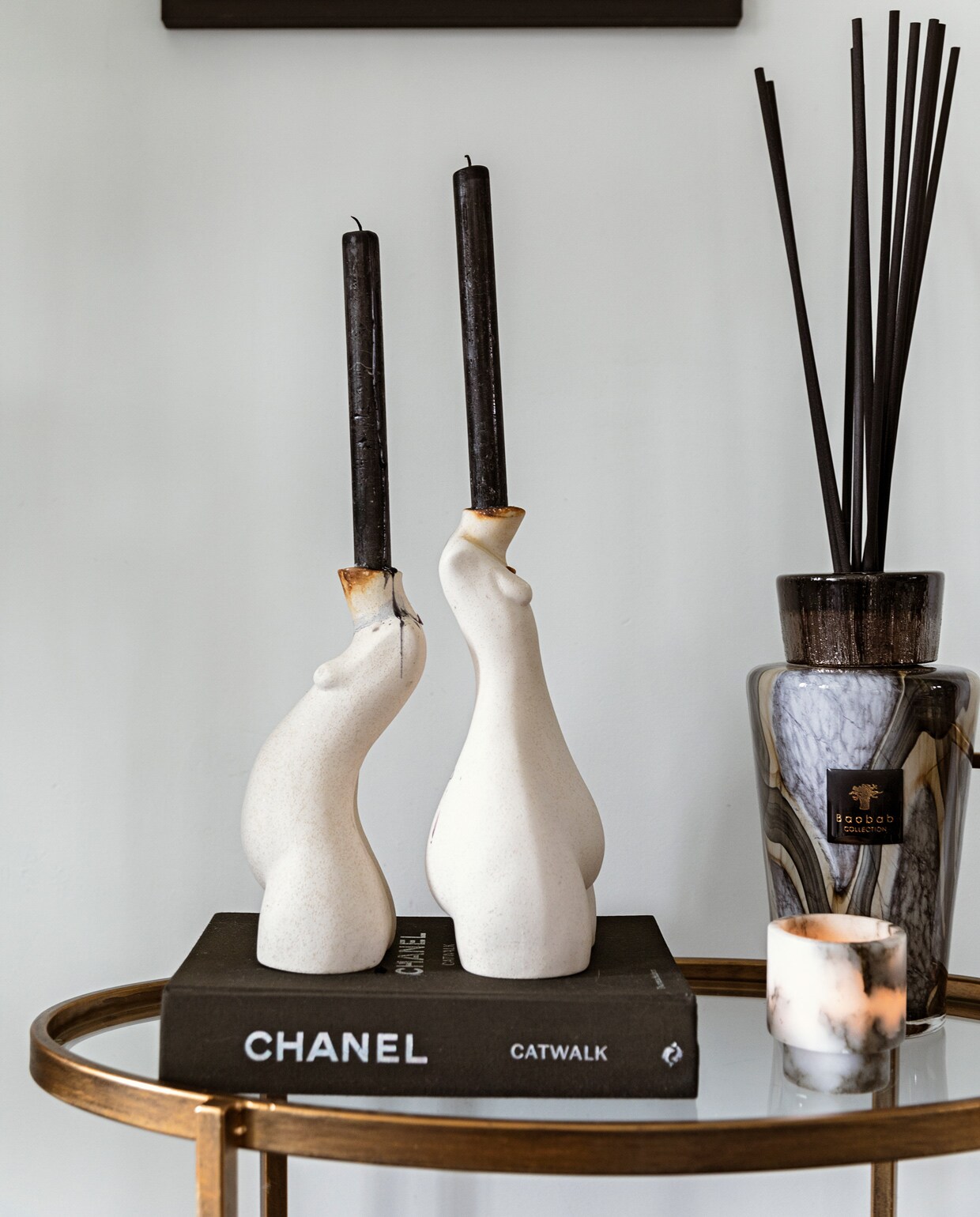 Bijzettafel BePureHome. Schilderij Cate Adriana. Boek Chanel. Kandelaars Anissa Kermiche. Geurstokjes Baobab. Kaarsenhouder Graanmarkt 13. vtwonen 11-2021 | styling Ilona Jongepier | fotografie Dana van Leeuwen | tekst Sara Madou | visagie Djolien de Kreij