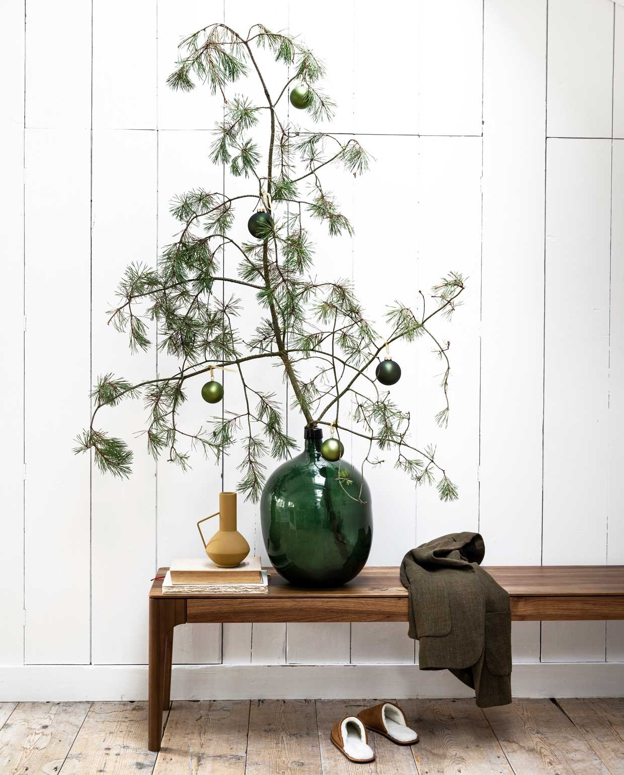 Walnoothouten bank Rikke van Sav &amp; Økse € 685,- (demachinekamer.nl). Vaas € 24,90 (nijhofbaarn.nl). Colbertjas € 39,95, suède sloffen € 29,99 (zara.com). Kerstballen vanaf € 1,89 (intratuin.nl). Overig privébezit. vtwonen 12-2021 | styling Moniek Visser | fotografie Stan Koolen
