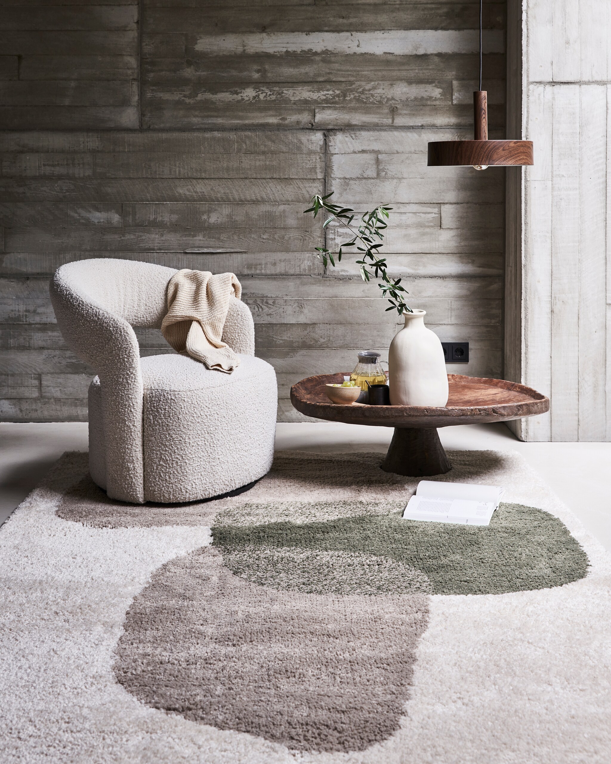 Hanglamp Woody van bruin metaal, 35×8 cm (Øxh) exclusief lichtbron € 99,-, (ook verkrijgbaar in formaat 27×8 (Øxh € 79,99). Vloerkleed Stepping Stones, 160×230 cm € 179,-.M.m.v. sofacompany.com (fauteuil), couleurlocale.eu (salontafel), vtwonen.nl (vaas). Overig privébezit vtwonen 11-2021 | styling Marlies Does | fotografie Bart Brussee