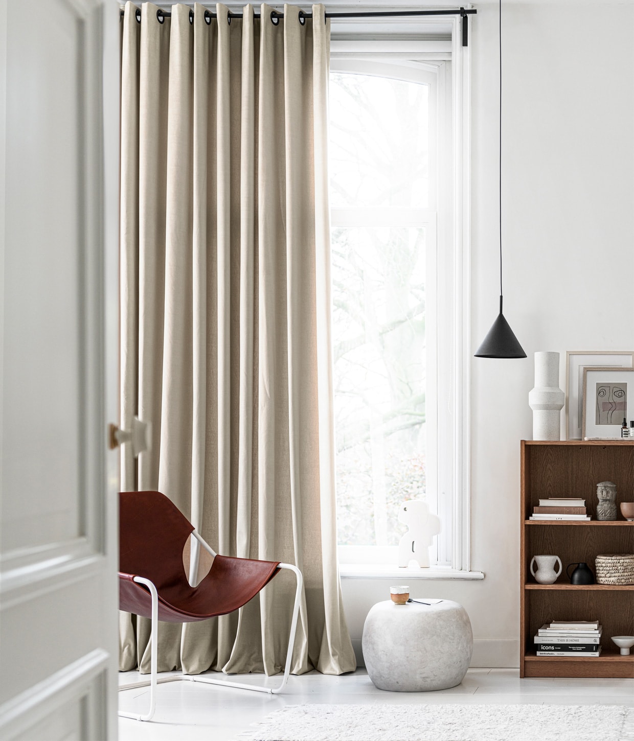 Gordijn op maat in stof Cosy kleur 1166, per meter € 31,99. M.m.v. extravert.nl (stoel met leer van Paulistano), basiclabel.nl (bijzettafel Pebble), hkliving.nl (hanglamp, vaas, object in vensterbank, mok op voet), loods5.nl (mok, vaas in kast, mand, grijs object, terra kom), wonderwallstudios.com (ingelijst kunstwerk). Overig privébezit. vtwonen 13-2020 | productie Tanja Saarberg | styling Marlies Does | fotografie Sjoerd Eickmans