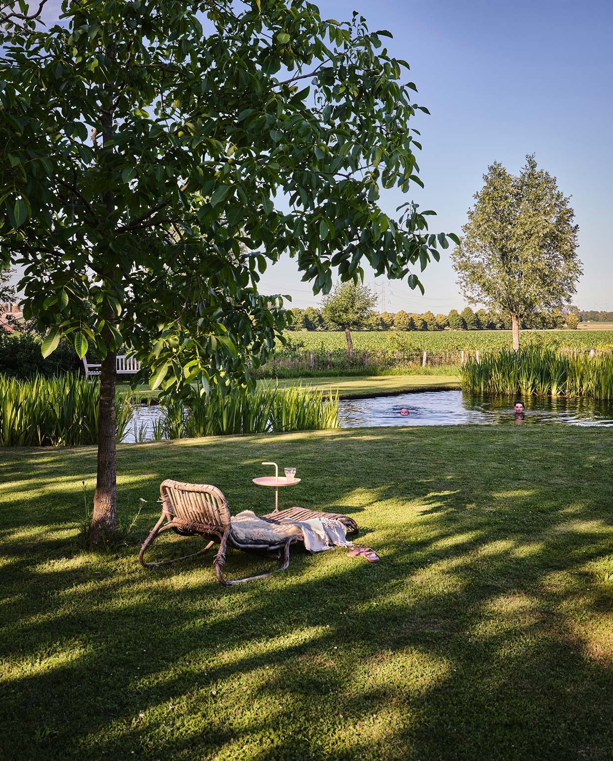 Daybed Piet-Hein Eek voor Ikea, erop een schapenvacht van Texels schaap. Zachtroze bijzettafeltje Hay. Hammamdoek Sissy-Boy Homeland. vtwonen tuin special 3 2021 | styling Carolien Schrievers | fotografie René van der Hulst