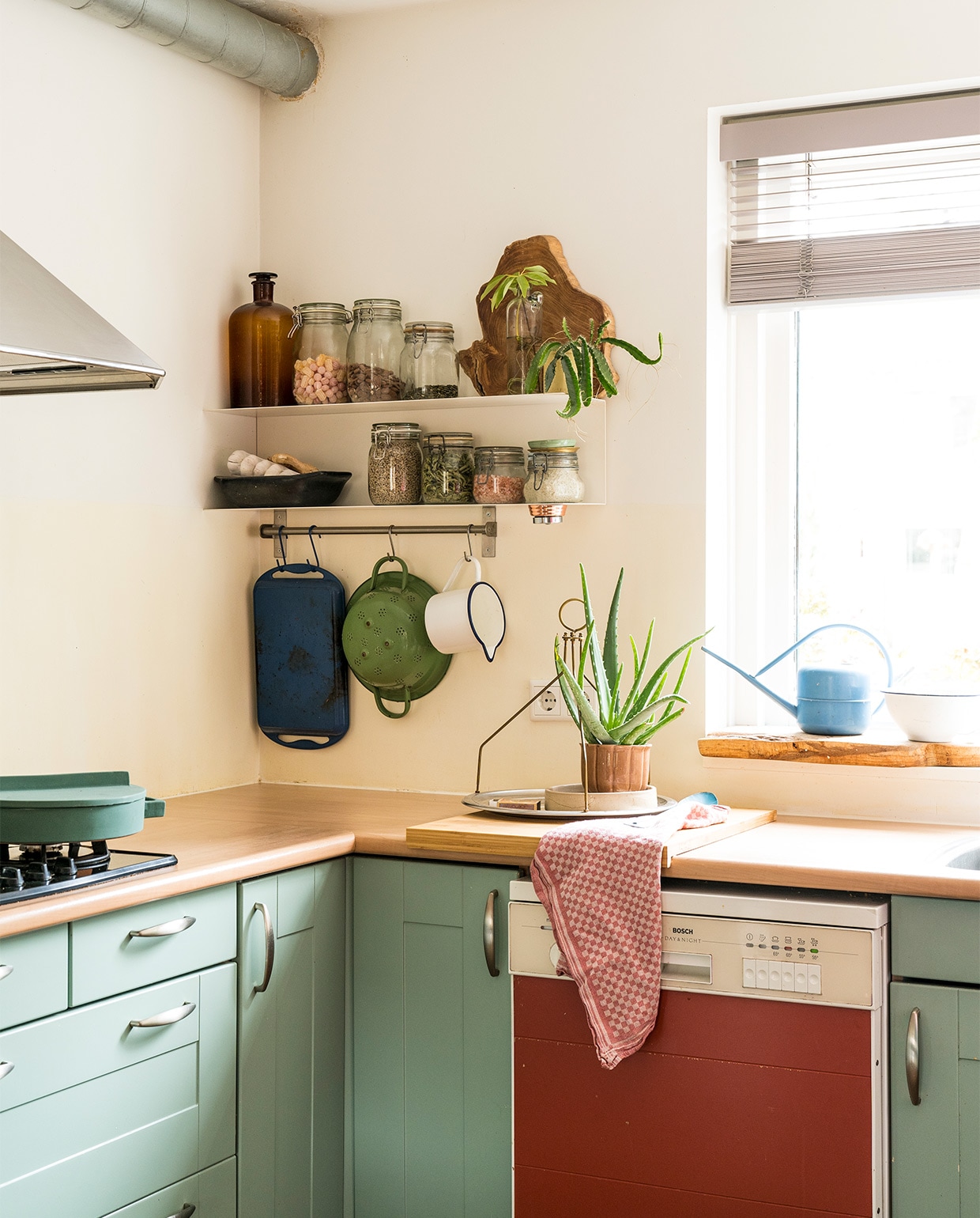 Verfkleur keuken Chappell Green van Farrow &amp; Ball. Vaatwasser Marktplaats. Pan Terracotto Sambonet. Metalen wandrek in U-vorm Ikea. Pannenrek Ikea. Grillplaat Le Creuset. Aardewerken ovenschaal fairtrade winkel. Keukendoeken Dille &amp; Kamille. Lamellen Luxaflex. Lamp Praxis. Overige kringloopwinkel. vtwonen 07-2021 | fotografie Muk van Lil | tekst Monique Butter