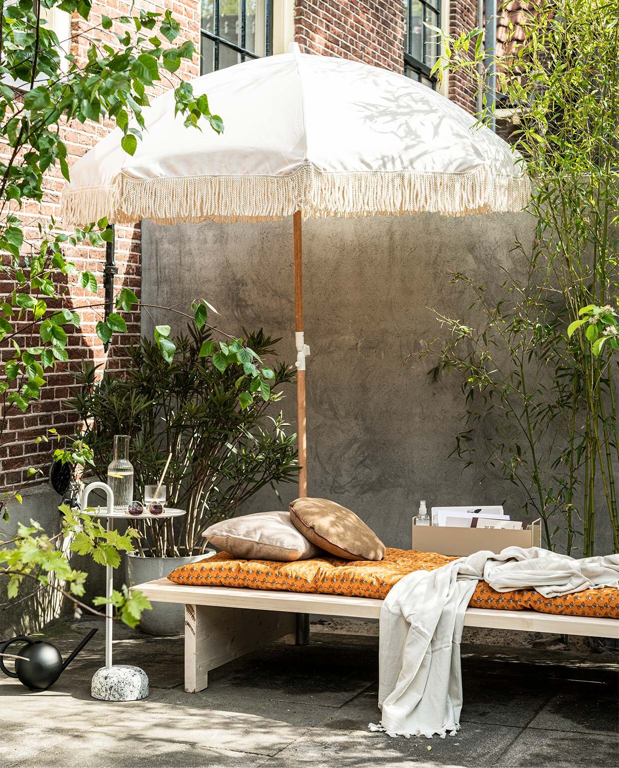 Parasol Dunes (sundaysupply.co). Matraskussen (zarahome.com). Zonnebril, gevlochten slippers (stories.com). Badlaken, glazen (hm.com). Bijzettafel Bowler van Hay, metalen box van Ferm Living in kleur Cashmere, geribbeld glas van Ferm Living (vtwonen.nl). vtwonen 06-2020 | styling Kim van Rossenberg | fotografie Sjoerd Eickmans