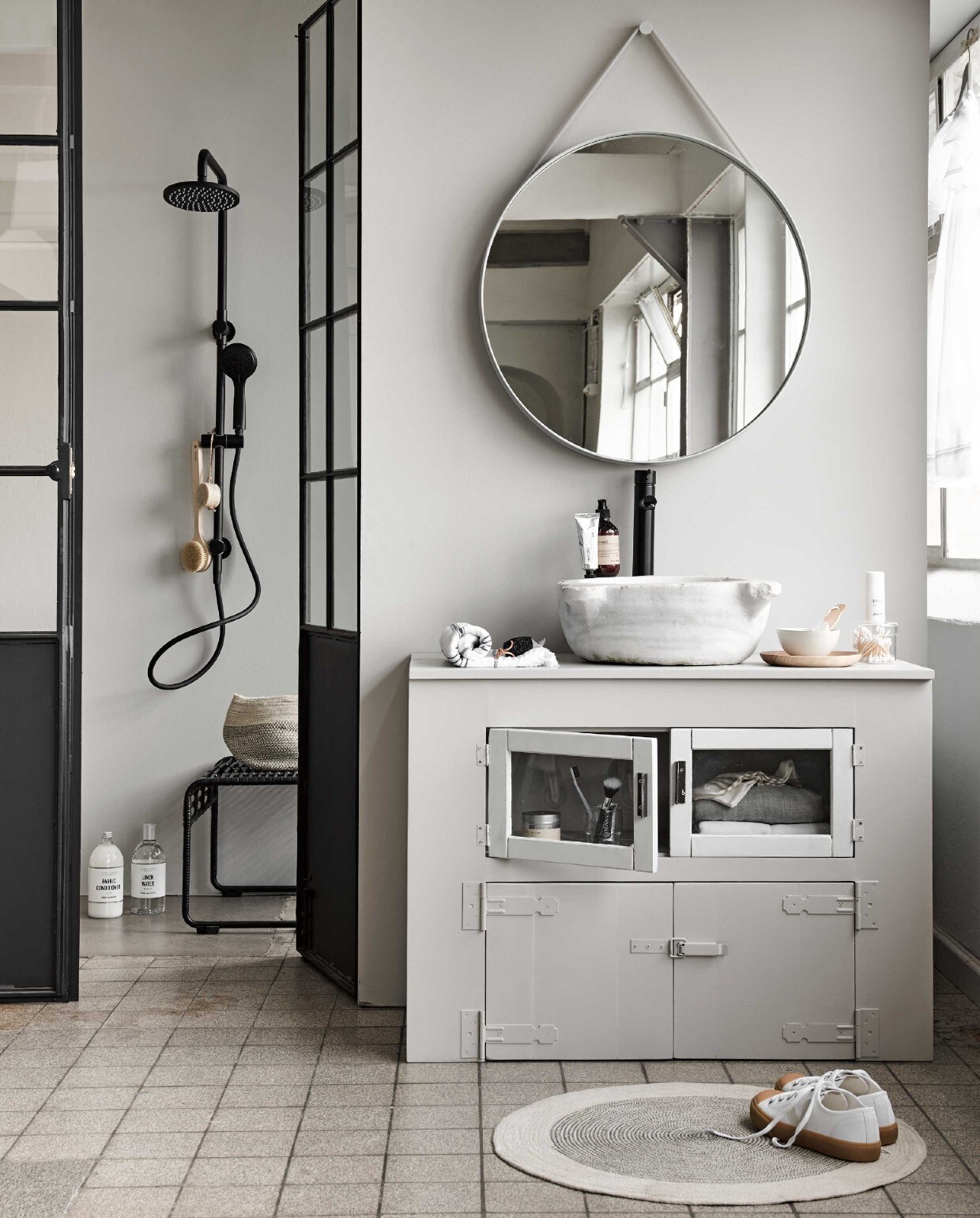 Wasbak met afvoer € 500,-, openslaande deuren € 1850,- (Jan van IJken Oude Bouwmaterialen). Wastafelmeubel prijs op aanvraag (Combitex). Kraan € 249,-, douche € 629,- (Mastello). Spiegel van Hay € 219,-, zeeppomp € 18,95, handcrème € 17,95, kruk House Doctor € 185,-, zwart-witte handdoek € 29,95, borstel € 24,95, rond zeepblok € 11,95, zwarte pedicuresteen € 6,95 (vtwonen.nl). Linnenwater € 12,99 (Zara Home). Mand € 14,99, kleed € 24,99, glazen bakje € 9,99 (H&amp;M Home). Schoenen € 99,99, sokken € 16,-, tandpasta € 4,90 (Six and Sons). Geurkaars € 22,50 (MaisonNL). Houten bord € 17,50, kommetje € 17,50 (Sukha Amsterdam). Overig privébezit. vtwonen 07-2018 | styling Liza Wassenaar | fotografie Alexander van Berge