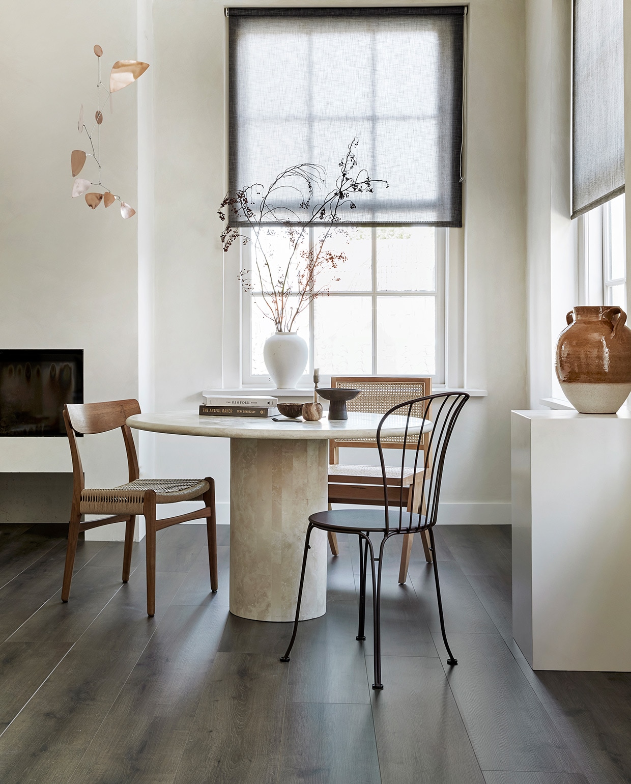 EVC vloer Rye per m² € 39,99. , M.m.v. karwei.nl (op maat gemaakt lichtdoorlatend rolgordijn in kleur 37850-700), pantoufle-design.nl (travertin tafel), misterdesign.nl (walnoothouten stoel CH23 van Carl Hansen), casagitane.com (schaal op poot), extravert.nl (bruine stalen stoel Opera van Fermob), aimetestudio.com (houten stoel met rotan zonder armleuning Pierre), zarahome.com (vazen), zenza.nl (alabaster waxinelichthouder), thefinestore.com (kandelaar van Menu), lpln.de (mobile van Lappalainen), bauwerkcolour.com (muurverf in kleur Mykonos). Overig privébezit. vtwonen 08-2021 | productie Tanja Saarberg | styling Kim van Rossenberg | fotografie Peggy Janssen