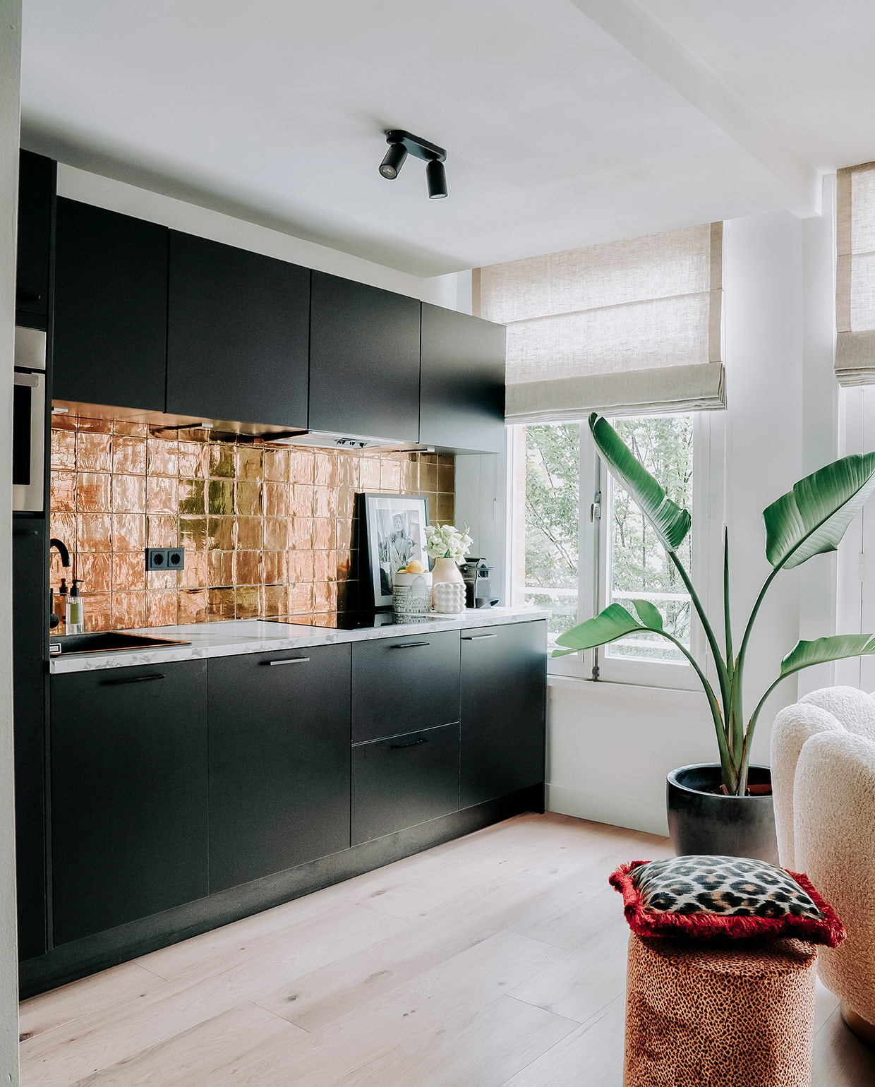 Keuken, marmeren werkblad en kraan Kooloos Interieurbouw. Tegels Megadump Tegels en Sanitair, vloer Nijhof. Zeeppompje en vaas Zara Home. Poef, kussen en schilderij Nox Studio Interiors. Plantenpot en plant Intratuin. Witte potten H&amp;M Home. vtwonen 06-2021 | productie CocoFeatures | fotografie Muk van Lil