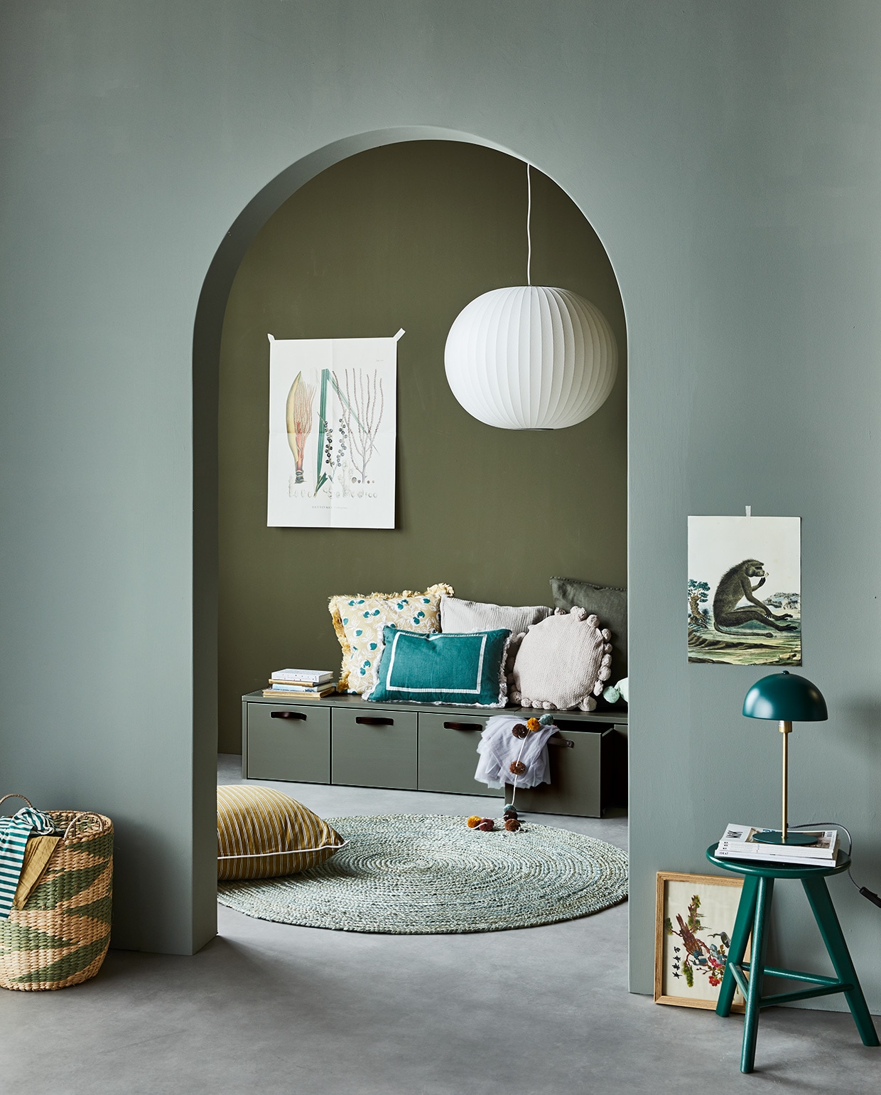 Muurverf op achterste wand Camouflage, op boog Soap. Grenenhouten kistbank Stage in kleur Soap van vtwonen, lamp van Hay, vloerkleed van Kave Home, mand en kussen met kwastjes van Bloomingville, staande lamp van Leitmotiv), palais.com (oker kussen met strepen, zeegroen kussen, geel gedessineerd kussen), neeflouis (kruk), zarahome (groen kussen, ecru kussen), hm.com (slinger, kussen met pompons), flo4kidz.nl (kleding). Overig privébezit. vtwonen 04-2021 | Styling Cleo Scheulderman | Fotografie Jeroen van der Spek