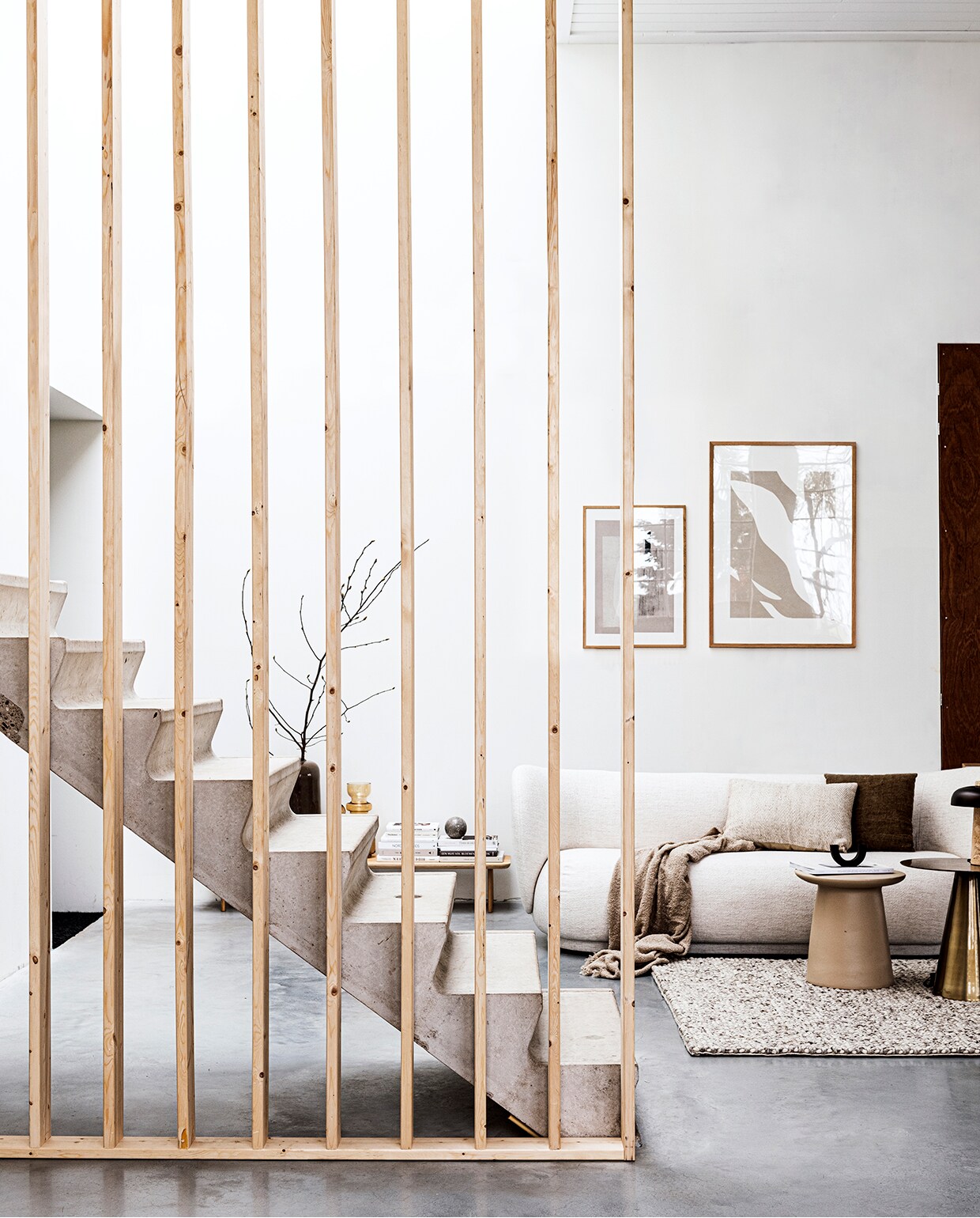 Laag houten wandmeubel Loof Piled, 24x150x35 cm (hxbxd), zwarte kandelaar Arch van Ferm Living (vtwonen.be). Marmeren bol, bouclé plaid 130×170 cm (hm.com). Grote vaas Jade achter trap, bruine glazen vazen achter trap, linnen kussens 40×40 cm en 40×60 cm (loods5.nl). Wollen vloerkleed Hjorthede, 160×230 cm (ikea). Messing bijzettafel 49×49 cm (Øxh), aardewerken bijzettafel 40×43 cm (Øxh) (hkliving). Bouclé 3-zitsbank Rico van Ferm Living, 210x79x81,5 cm (bxhxd) (flinders.nl). Posters: groot Fragments van Moe Made It, 70×100 cm met eikenhouten lijst klein Carrarra van Julia Hallström Hjort, 50×70 cm met eikenhouten lijst (theposterclub.com). Boeken privébezit. vtwonen 2020 DIY special 01 | productie &amp; styling Kim van Rossenberg | uitvoering Richard van Meerveld | fotografie Sjoerd Eickmans
