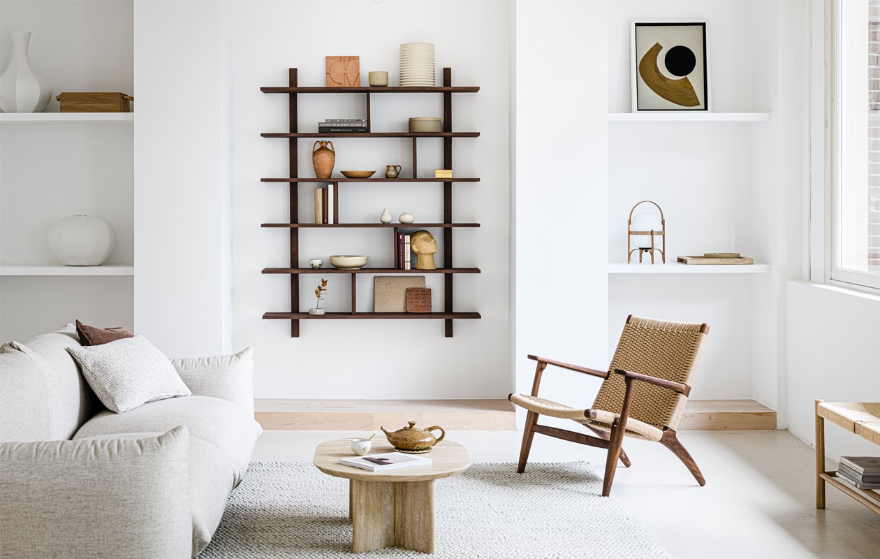 Bank Arflex design by Mario Marenco € 3850,-, handgeweven wollen kussen 40×60 cm € 125,-, travertin salontafel Bean Table € 1074,-, vintage theepot prijs op aanvraag, messing onderzetter van Futagami € 85,-, witte theekop Takashi € 46,50, messing lepeltje € 45,-, fauteuil CH25 van designer Hans J. Wegner voor Carl Hansen &amp; Søn, in walnoot uitvoering € 3380,-, terracotta tegel prijs op aanvraag, bruine mok van J.C. Herman € 22,-, aardewerken schaal met deksel Hasami € 54,-, vintage terracotta vaas prijs op aanvraag, vintage aardewerken schaal prijs op aanvraag, vintage kannetje prijs op aanvraag, goudkleurig doosje van SyuRo € 39,-, wit kopje Takashi € 35,-, schaal van J.C. Herman € 42,50, tegel groot en klein prijs op aanvraag, oplaadbare tafellamp Cesta Led in kast € 465,- (pantoufle-design.nl). Magazine € 22,- (thefinestore.com). Vloerkleed Peas van Hay, 200×300 cm € 935,-, beige ribbelvaas Aleray van Kave Home € 38,- (vtwonen.be). Grijs kussen € 59,50, beige keramieken vaasjes per stuk € 11,90, sculptuur gezicht € 27,50 (loods5.nl). Overig privébezit.