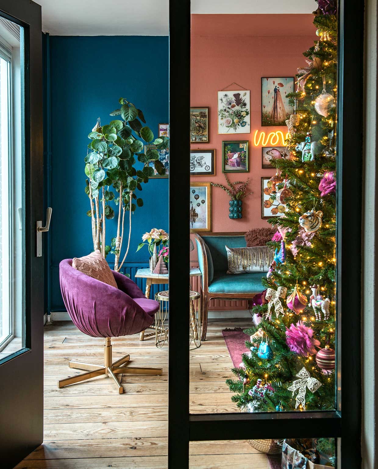 Het roze stoeltje van Ikea kreeg een nieuwe bekleding. De petrol sofa is tweedehands gekocht op Marktplaats. De prints komen van postershop desenio.nl. Neon lamp gekocht bij Kwantum, vloerkleed van Bold Monkey. Hangvaas van Atelier W. Tafeltje rond van Leen Bakker, achthoekig tweedehands. Papieren en stenen boompjes van Intratuin. Grote kunstboom Tuinland. vtwonen 12-2020 | Styling Mindy Schroor | Fotografie Ton Bouwer | Productie Monique van der Pauw
