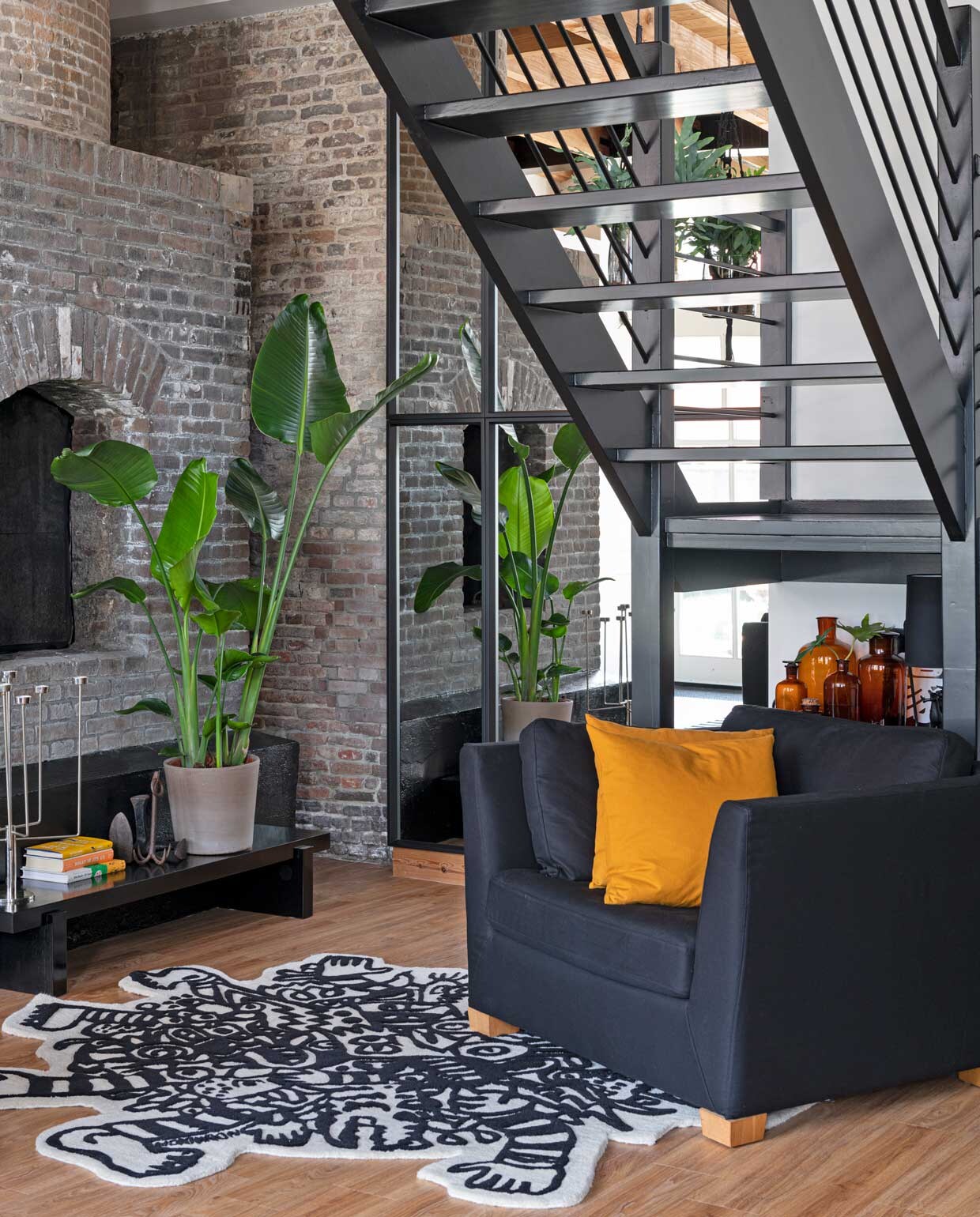 Fauteuil, vloerkleed en zwartgeverfde tafel Ikea. Anker van rommelmarkt, kandelaar Habitat, kussen H&amp;M Home, apothekers-flessen van Marcels moeder. Houten raamwerk met spiegelglas op maat laten maken. vtwonen special binnenkijken 12-2020 | styling Sharon Roest | fotografie Caroline Martinot