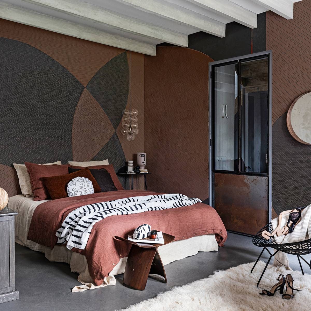 Behang Ego, per m² € 91,- (glamora.it). Spiegel Stockholm € 79,95 (ikea.com). Zwarte draadstalen stoel € 475,- (paullelieveld.com). Vloerkleed, 140×200 cm (lxb) € 268,- (therealrugcompany.co.uk). Zwarte wandtafel € 179,95 (loods5.nl/design). Vaas met geschilderd hoofd € 24,99, aardewerken kandelaar € 14,99, zwart vaasje € 7,99, geurkaars in bruine glazen pot € 4,99 (hm.com). Hanglamp van House Doctor € 89,85 (vtwonen.be). Linnen dekbedovertrek in de kleur terra, vanaf € 139,-, linnen kussenslopen in de kleuren terra en wheat, per stuk € 28,-, linnen laken in de kleur wheat € 119,- (bymolle.com). Vierkant sierkussen van stof Georgetown 7716-6, per meter € 34,95 (eijffinger.com). Langwerpig sierkussen van teddystof Bolke Terra € 6,-, rond sierkussen gemaakt van stof Gina € 6,- (kwantum.nl). Sprei van stof Paris Lipari van Nobilis € 130,- (wva.nl). Bijzettafel € 795,-, toilettas € 50,- (coosdewitwonen.nl). Overig privébezit. vtwonen 03-2020 |  styling styling Danielle Verheul | fotografie Sjoerd Eickmans