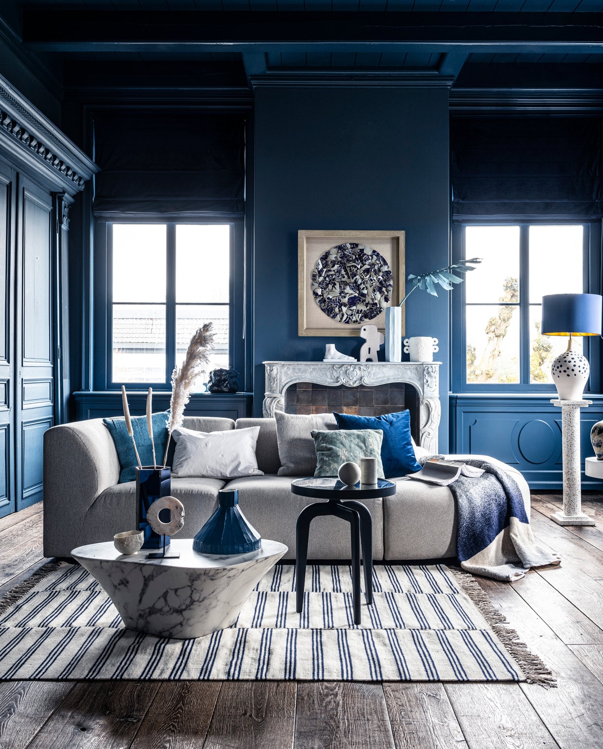 Voet op schouw € 59,95, sierobject op schouw € 58,95, pilaar € 239,-, wit bijzettafeltje € 269,-, witte vaas € 38,35, schilderij prijs op aanvraag (hkliving.nl). Velours stoel € 1200,- (edha-interieur.nl). Kleed € 199,- (zarahome.com). Marmeren salontafel € 587,50, blauwe tak € 57,- (polspotten.nl). Blauwe salontafel Schönbuch € 719,-, plaid Mae Engelgeer € 440,-, wit kussen Mrs.me € 99,- (homestede.nl). Blauw kussen € 49,-, ecru kussen € 49,-, blauw kussen op stoel € 49,- (couleurlocale.eu). Wandlamp It’s about RoMi Chicago € 355,-, kussen Sarona vintage blue 45×45 cm € 35,- (polspotten.nl). Velvet sierkussen 55×55 cm € 74,-, donkerblauwe vaas met tak (klevering.nl), zeshoekige vaas 32 cm hoog € 38,99,-, cockatoo decoratie € 53,- (polspotten.nl), bank Jax hkliving.nl, element vanaf € 499,- (vtwonen.nl). Blauwe vaas, smal toelopend € 469,-, cirkelvormig sierobject € 129,-, wit bankje op tafel, prijs op aanvraag, lichtblauwe vaas 46 cm hoog € 239,-, marmeren pot op blauwe salontafel € 45,-, opengeslagen boek € 40,- (badenbaden.nl). Stoel rechts € 1898,-, sierbal op blauwe tafel, set van 3 € 99,-, houten siervorm op bijzettafel, set van 3 € 99,- (covanderhorst.nl). Schoenen € 34,99 (hm.com). Lampenvoet met stippen € 798,-, gordijnstof 295 cm breed, per meter €103,- (wva.nl). Blauw gevlekte vaas op bijzettafel € 235,95, blauwe kleine pilaar € 66,55, blauwe lampenkap € 332,75, wandbord per twee, € 235,95, marmeren schouw Lodewijk XIV, € 15.125,-, 18e eeuwse houten vloer per m2, € 168,19 (pietjonker.nl). Witte serax vaas op schouw € 40,85 (loods5.nl). Overig privébezit. vtwonen 07-2020