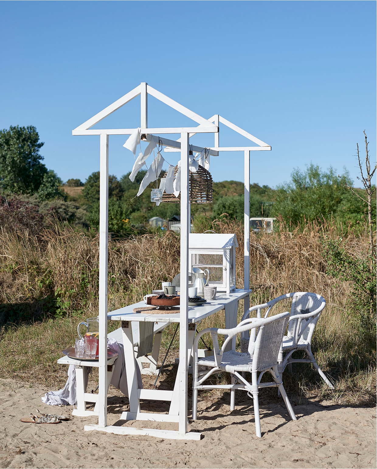 Mand (lamp) Goround Interior. Hamamdoeken ’t Sieraadje. Tafel, bank en stoelen Timzowood. Opbouw tafel zelfgemaakt, versierd met repen linnen. vtwonen zomerboek 2020 | binnenkijken Egmond