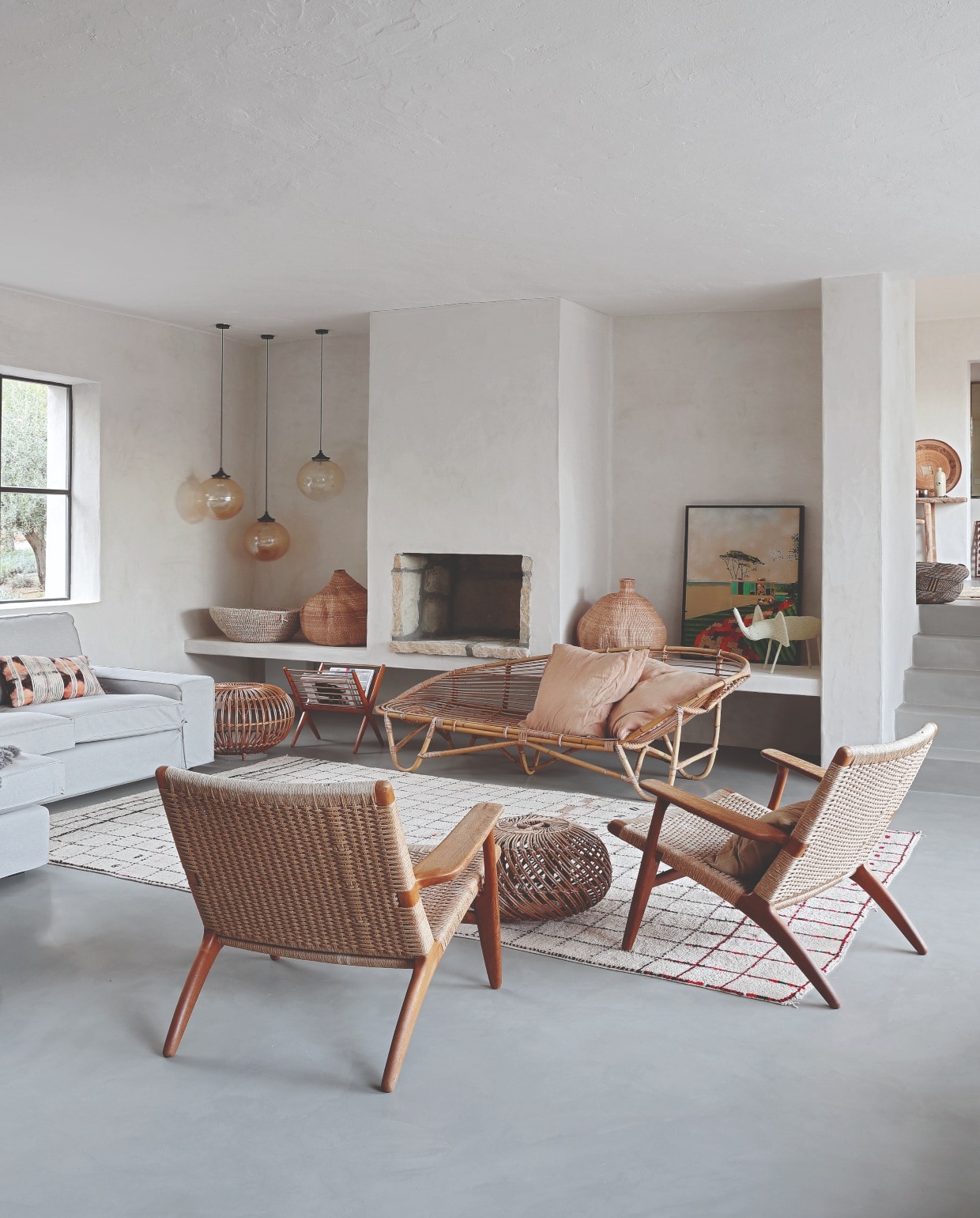Hanglampen Retrouvius, Hans J. Wegner stoelen van Mid Century Antiques, beide in Londen. Rotan zetel Homeplace, Berber vloerkleed uit Marokko. Grijze zetel Ikea, schapenvachten The Organic Sheep. Schilderij van de Australische kunstenaar William Mackinnon vtwonen 07-2020 | productie Frank Features | fotografie Elsa Young