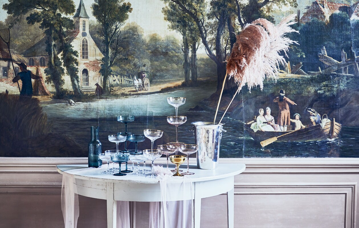 Geribbelde en gouden coupes, karaf van groen glas, goudkleurig taartplateau (hm.com). Coupe met goudkleurige rand (nordal.eu). Halfronde tafel, verzilverde champagnekoeler, beide (prinsheerlijkantiek.nl). Grote champagnekoeler (iblaursen.dk). Tule (boerenbonthal.nl). Whiskykaraffen (nordal.eu). Wijde glazen (hkliving.nl). Styling Cleo Scheulderman | Fotografie Jeroen van der Spek