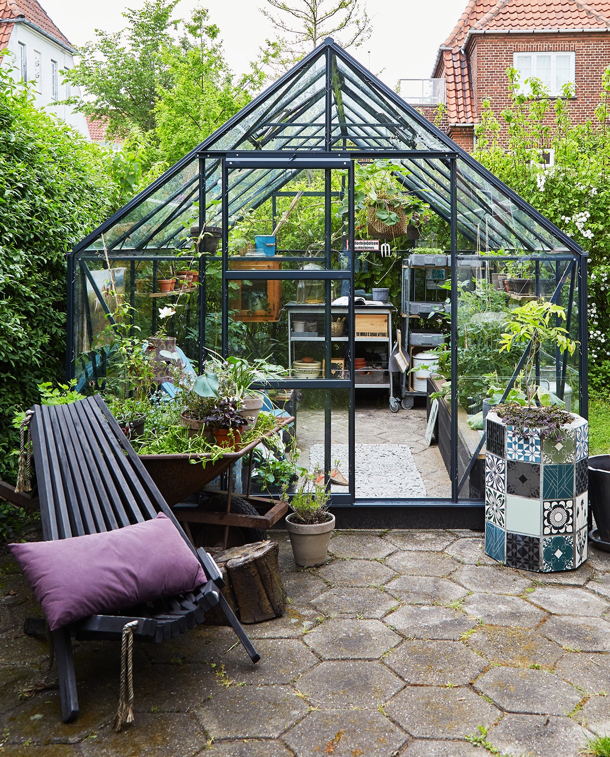 Voor doorgewinterde tuiniers is een tuinkas de hemel op aarde. Hij is zo gebouwd dat hij bij het minste zonnetje al goed opwarmt, waardoor je heel vroeg in het jaar bloemen, fruit en groenten kunt zaaien, telen en stekken. Ook kun je planten die niet vorstbestendig zijn hier laten overwinteren. Planten die in de kas zijn opgekweekt, kunnen in de lente naar buiten, waar het dan inmiddels warm genoeg voor ze is. Eigenlijk verschuif je met een kas de seizoenen. Maar ook voor de wat minder geroutineerde tuiniers is een kas een aanwinst: zodra de zon zich even laat zien kun je de tuin in en zit je warm tussen het glas. Op zoek naar een kas? Kijk bijvoorbeeld op boerenbond.nl, tuinexpress.nl, tuinadvies.nl. vtwonen tuin special 1 | buitenplaats met donker glazen kas Kopenhagen