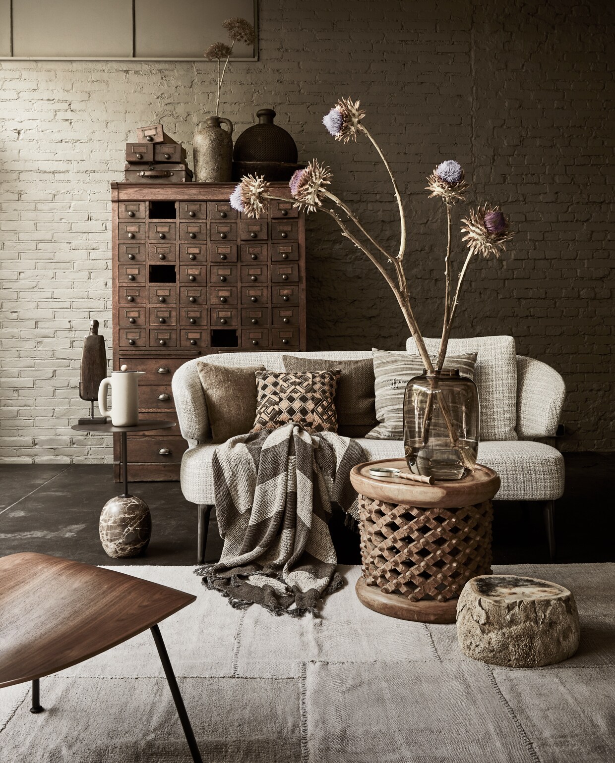 Bank van Minotti (covanderhorst.nl). Antieke kast, 107x124x35 cm (lxbxd) (burbri.nl). Koffiemaker push van Muuto, glazen vaas, bijzettafel met marmeren voet, houten stoel plywood LCM walnut van Vitra, kunsttakken prijs op aanvraag, vaas met oor, kussen links 40×40 cm, gestreepte plaid, 130×170 cm, beelden prijs op aanvraag (loods5.nl). Kussen met ruitprint, bruin kussen 50×50 cm, vloerkleed 307×248 cm, salontafel 50×45 cm (Øxh) (couleurlocale.eu). Vergrootglas (zarahome.com). Siersteen Petrified (thewunderkammer.eu). Gestreept kussen (badenbaden.nl). Vaas rechts op kast privébezit. vtwonen 13-2019 | styling Liza Wassenaar | fotografie Alexander van Berge