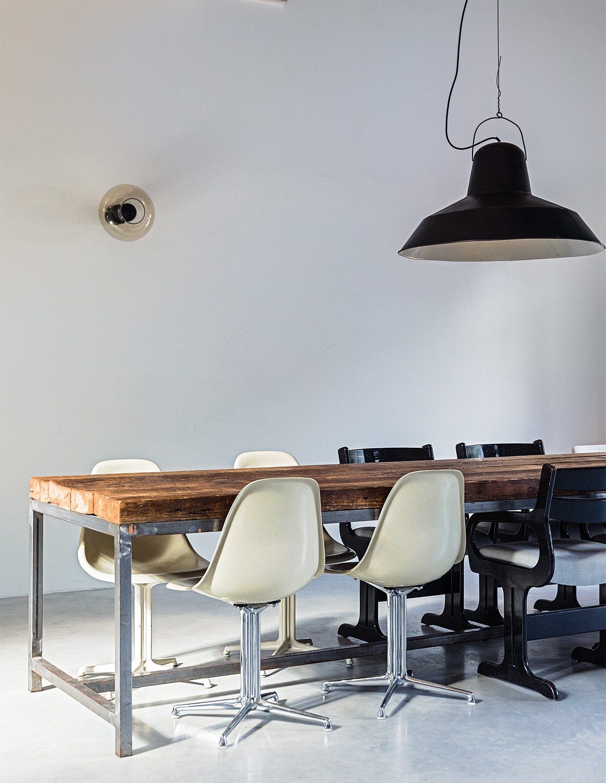 Eettafel, stoelen en lampen vintage. Vloer van gevlinderd beton via Bako Beton.